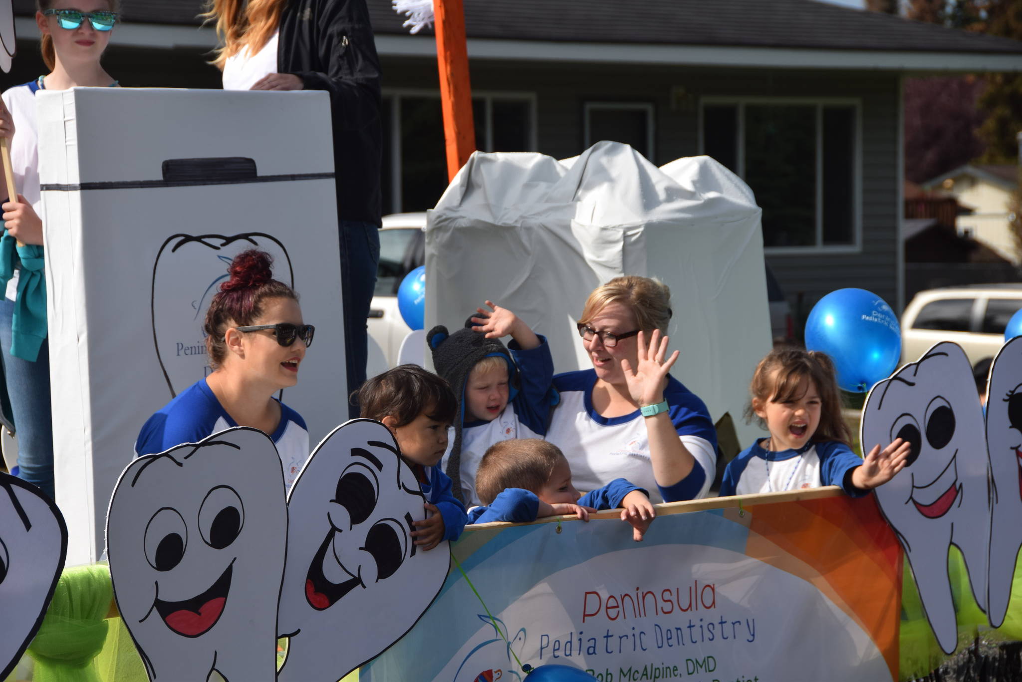 Volunteers from Peninsula Pediatric Dentistry wave to the crowd during Soldotna’s Progress Day Parade in Soldotna, Alaska on July 27, 2019. (Photo by Brian Mazurek/Peninsula Clarion)