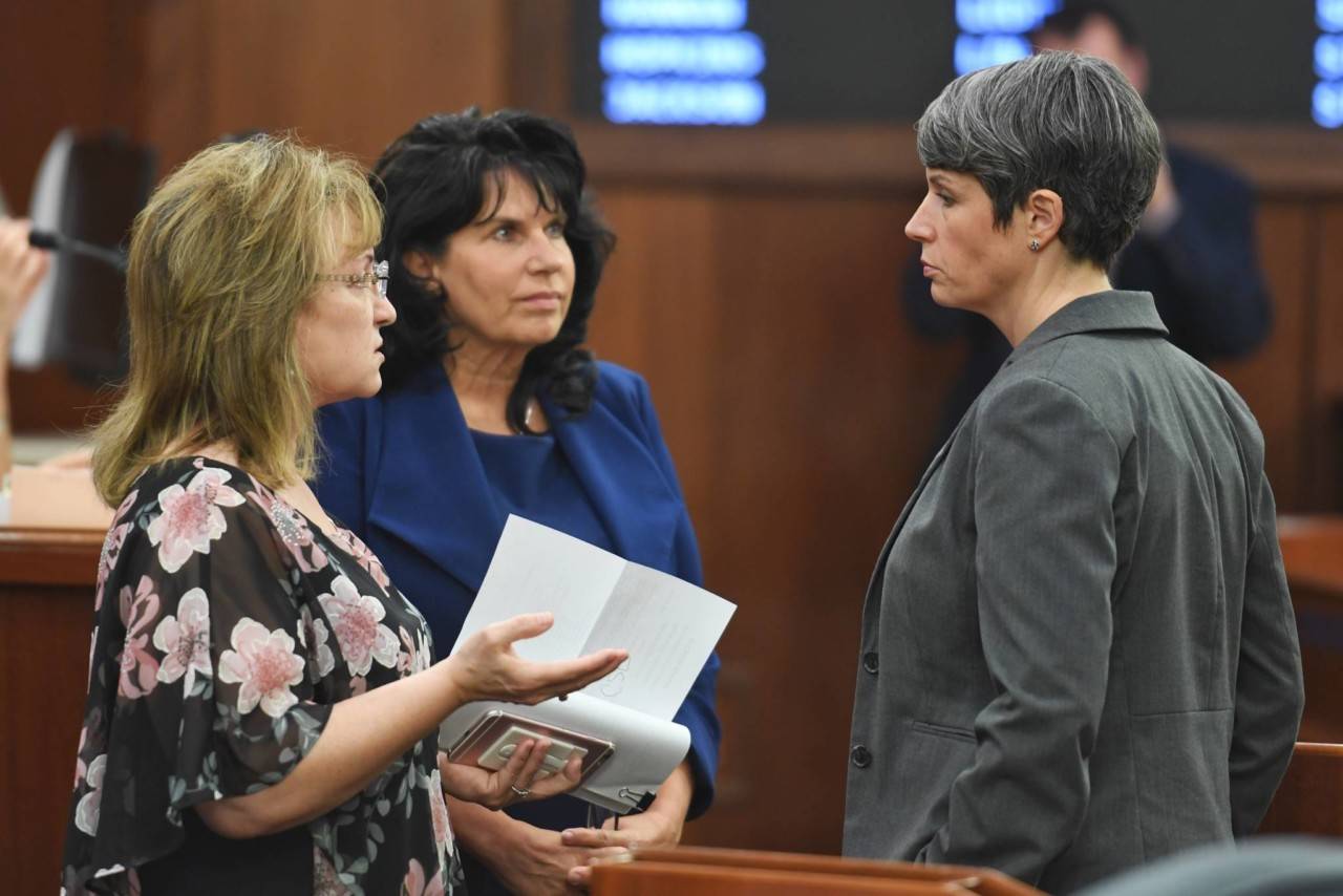 Rep. Colleen Leonard-Sullivan, R-Wasilla, left, Rep. Cathy Tilton, R-Wasilla, center, and Rep. Sarah Vance, R-Homer, speak together before a reconsideration vote HB 2002 at the Capitol on Monday, July 22, 2019. The three representatives voted no on the bill. (Michael Penn | Juneau Empire)