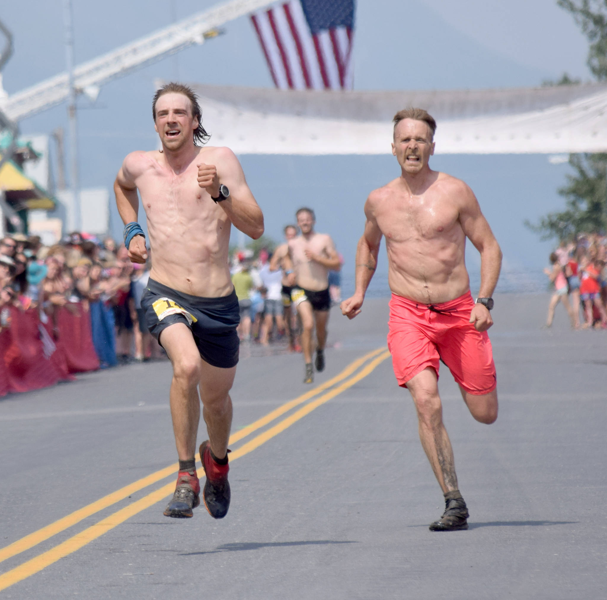 Pyper Dixon and Erik Johnson, both of Seward, sprint for the finish of the Mount Marathon Race on Thursday, July 4, 2019, in Seward, Alaska. (Photo by Jeff Helminiak/Peninsula Clarion)