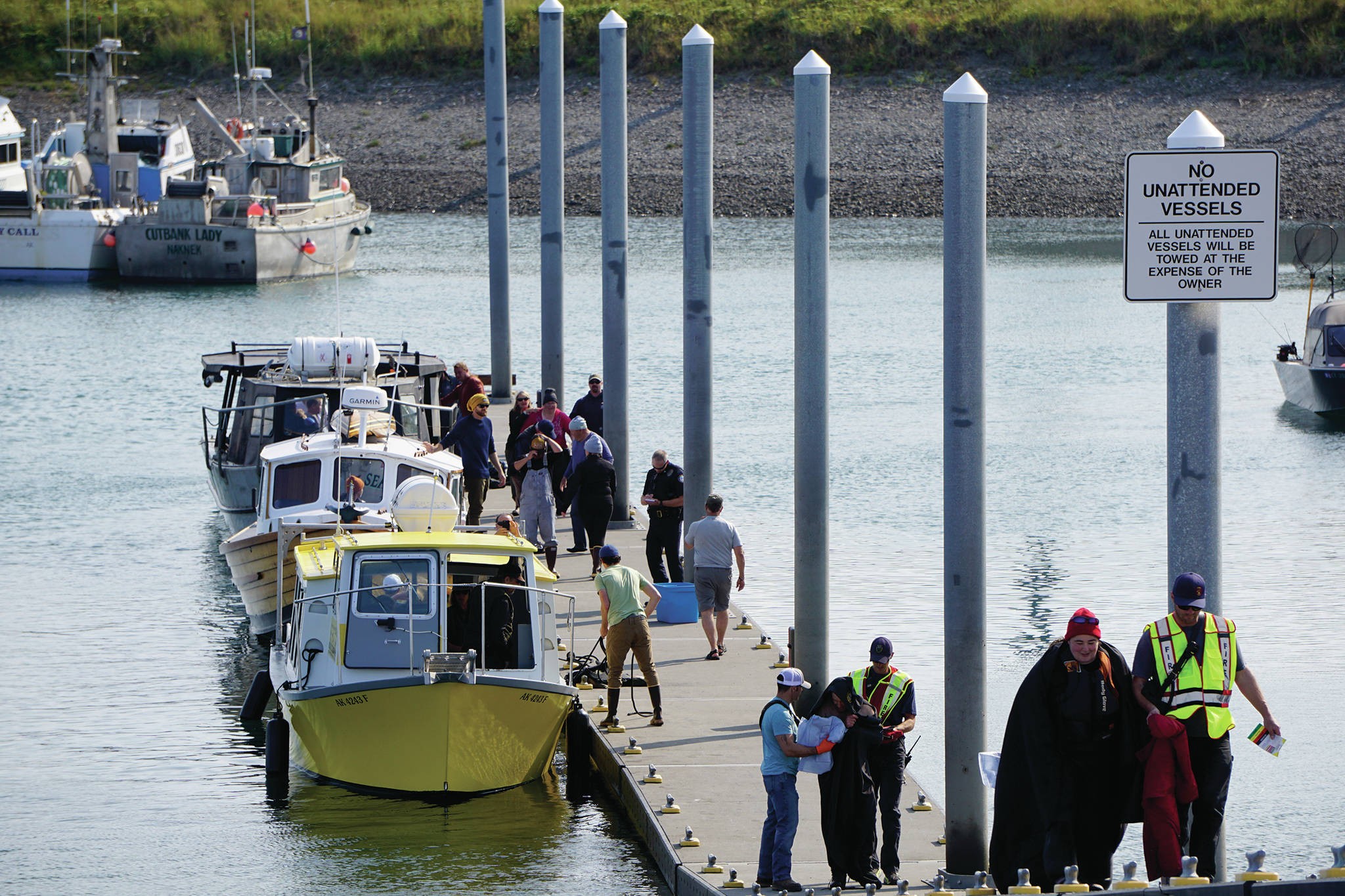 Emergency medical technicians help victims of a boat capsizing up the Homer Harbor load and launch ramp on Tuesday afternoon, July 30, 2019, in Homer, Alaska. Crews in three Good Samaritan boats, from front to back, the Torega, the Grotta Nove, and the Seabird, rescued five people from an overturned skiff near China Poot Bay. (Photo by Michael Armstrong/Homer News)