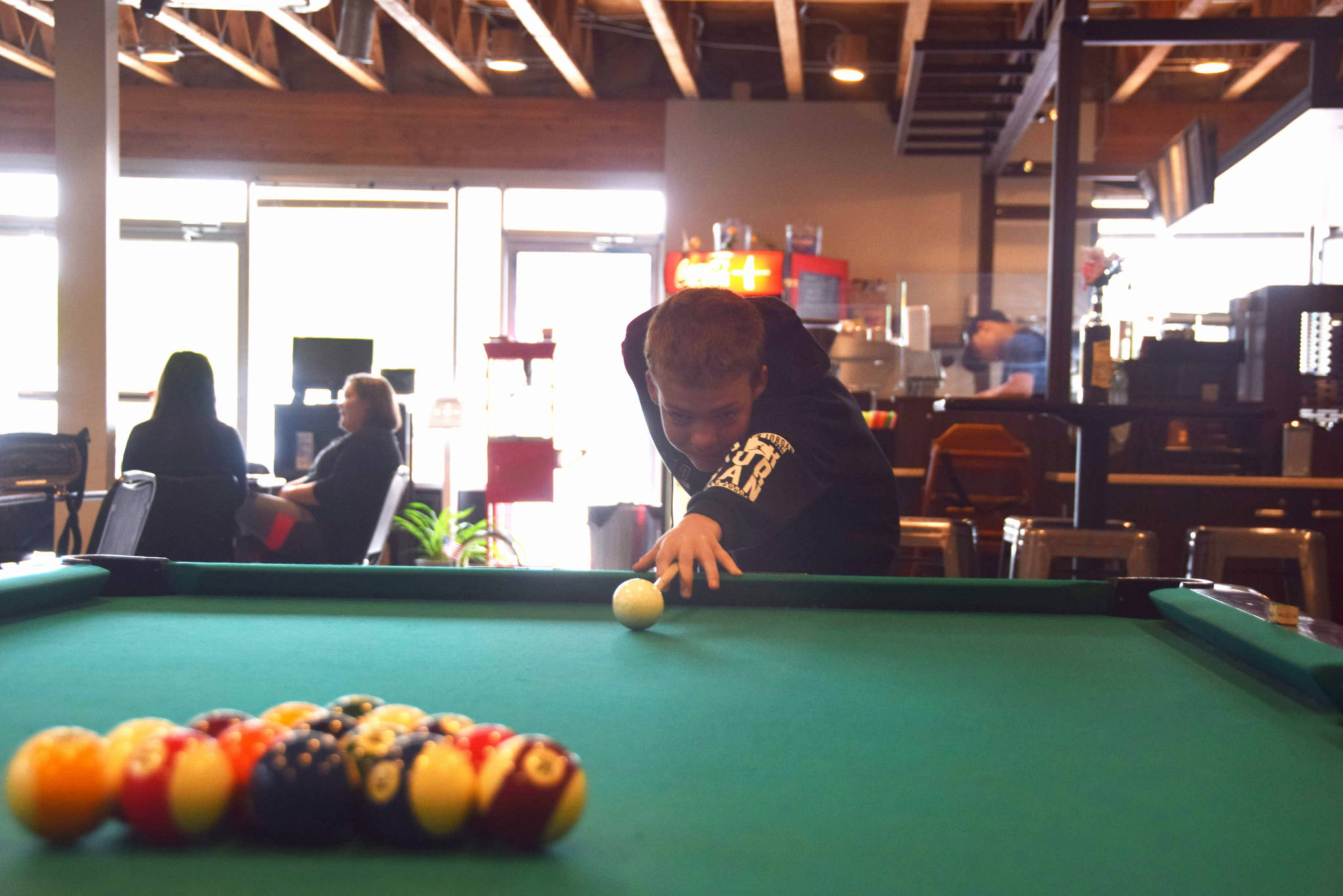 Brian Mazurek / Peninsula Clarion                                Brock Van Eaton lines up his shot on July 24 at the Compass in Nikiski, Alaska.