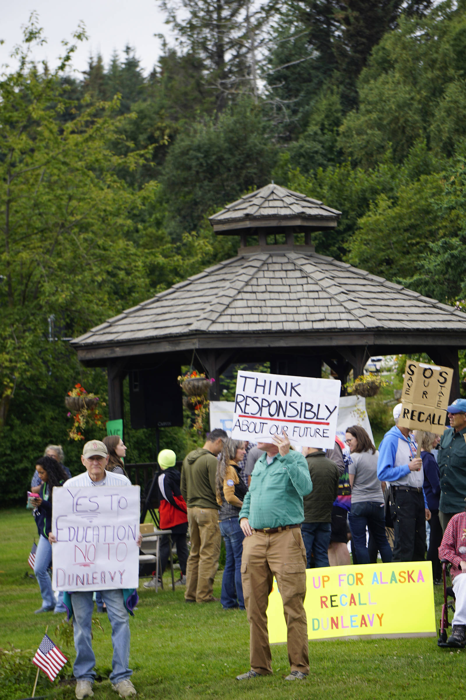 Recall Dunleavy supporters hold signs at a Recall Dunleavy rally held on Aug. 1, 2019, at WKFL Park in Homer, Alaska. (Photo by Michael Armstrong)