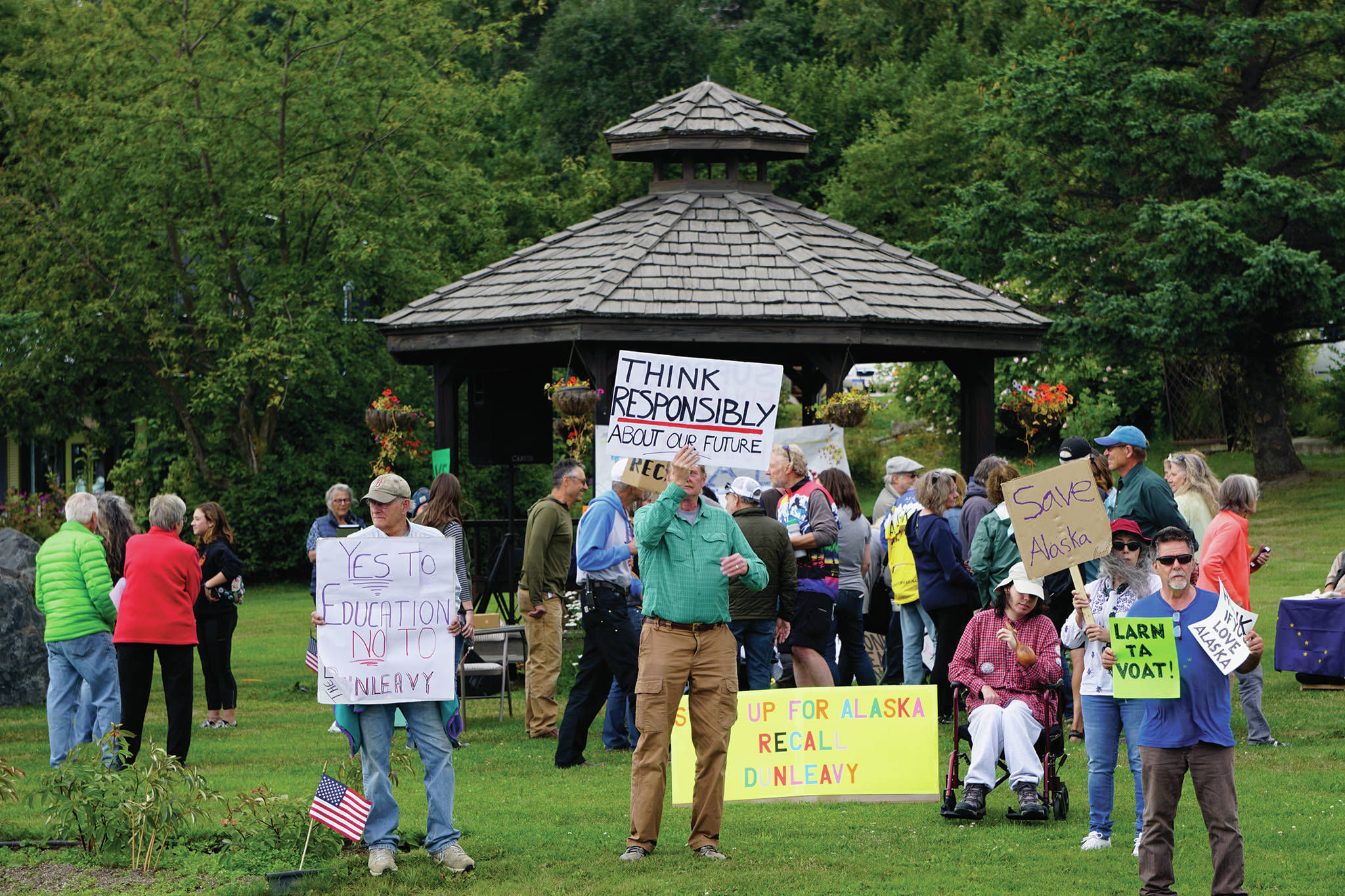 Recall Dunleavy supporters hold signs at a Recall Dunleavy rally held on Aug. 1, 2019, at WKFL Park in Homer, Alaska. (Photo by Michael Armstrong)