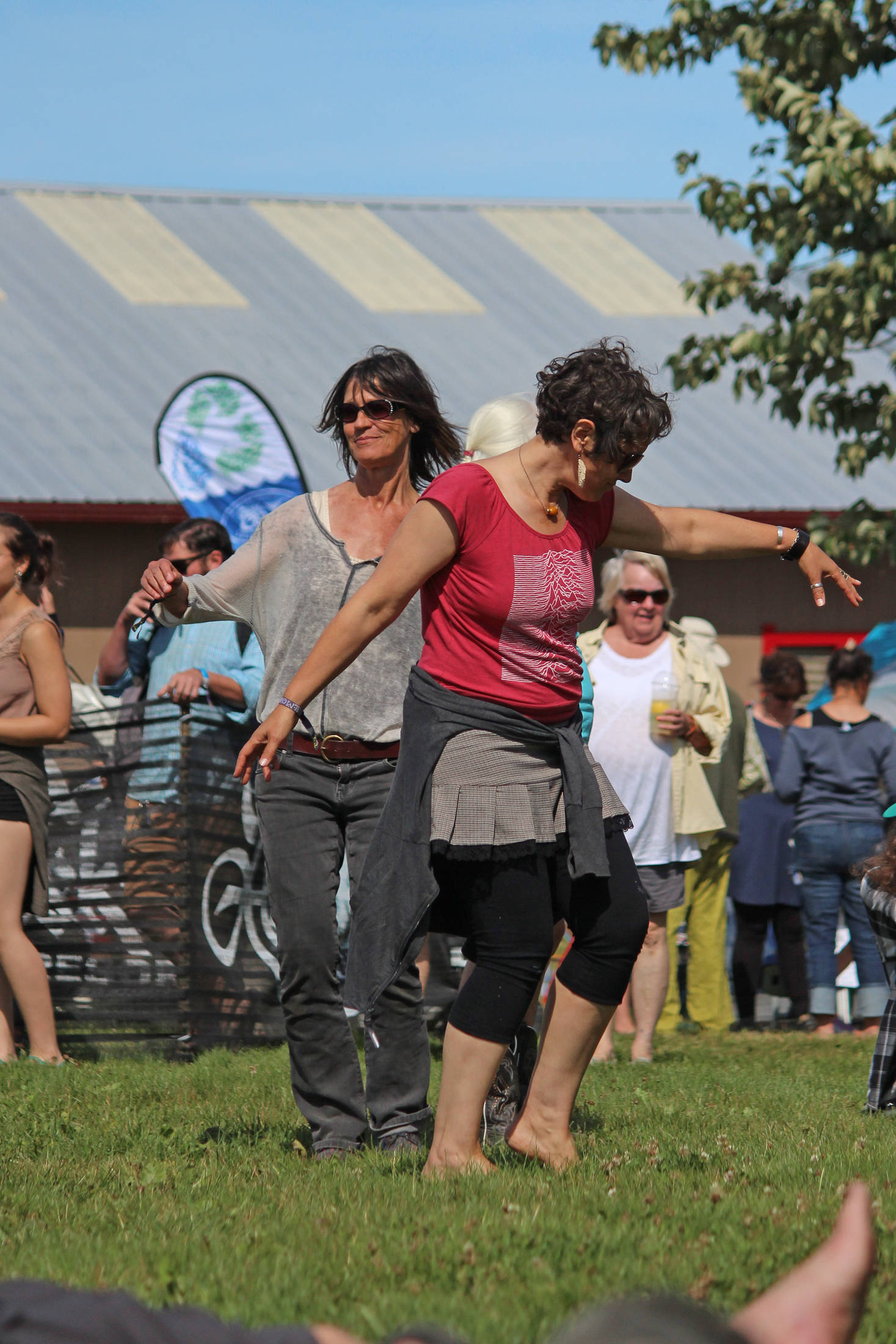 Women dance in the grass during a performance at the Ocean Stage on Friday, Aug. 2, 2019 at Salmonfest in Ninilchik, Alaska. (Photo by Megan Pacer/Homer News)