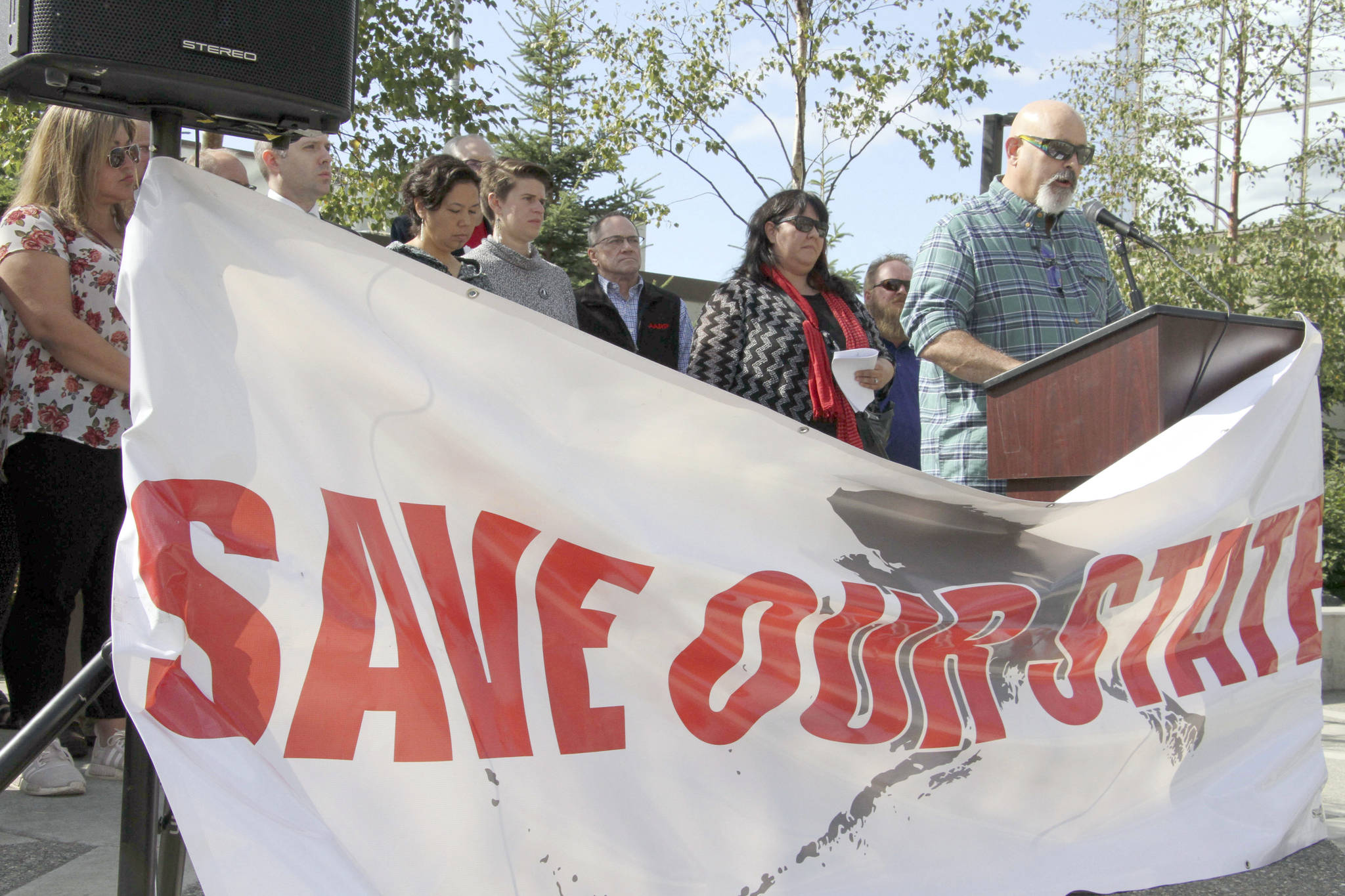 Vince Beltrami with the Alaska AFL-CIO, right, speaks at a news conference Wednesday, Aug. 7, 2019, in Anchorage, Alaska. Beltrami and representatives from more than two dozen organizations are asking Alaska Gov. Mike Dunleavy to not cut money for early education and social service programs from the state’s budget. (AP Photo/Mark Thiessen)