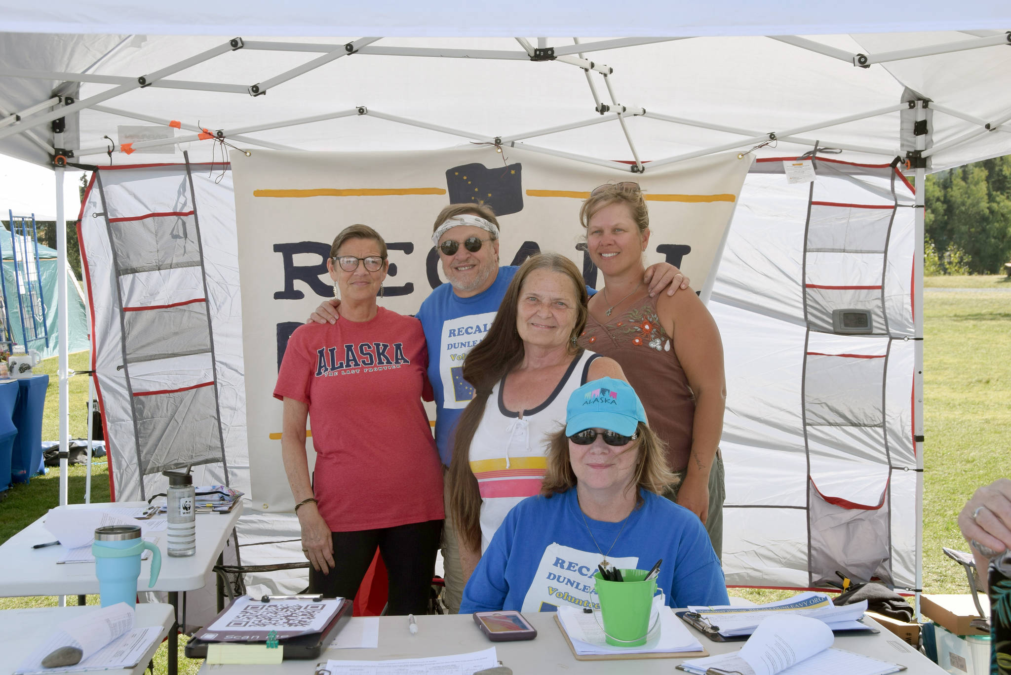 From left, Michele Vasquez, Eric Trieder, Fay Herold, Nelma Treider and Karyn Griffin smile for a photo while collecting signatures to recall Governor Mike Dunleavy in Soldotna Creek Park on Aug. 7, 2019. (Photo by Brian Mazurek/Peninsula Clarion)