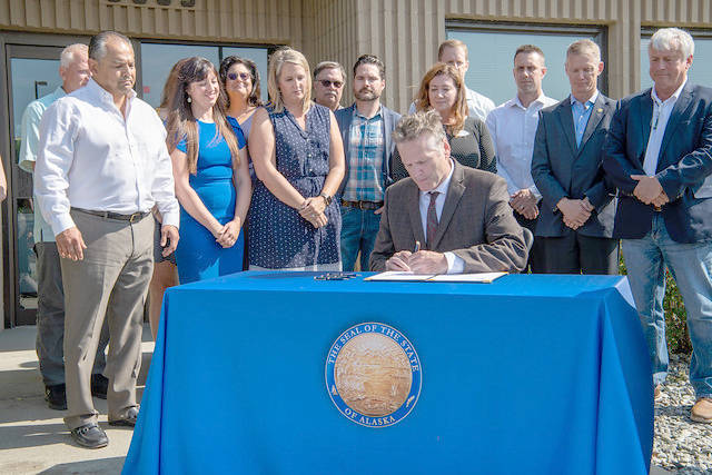 Gov. Mike Dunleavy signs SB 2002 at the Alaska Association of General Contractors in Anchorage on Thursday, Aug. 8, 2019. (Courtesy photo)