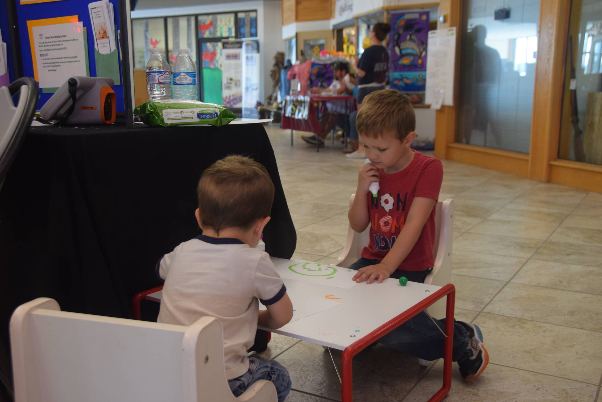 Mason Clark, left, and Bridger Clark, right, practice their art skills at the Frontier Community Services booth during KidFest at the Peninsula Center Mall in Soldotna, Alaska on Aug. 10, 2019. (Photo by Brian Mazurek/Peninsula Clarion)