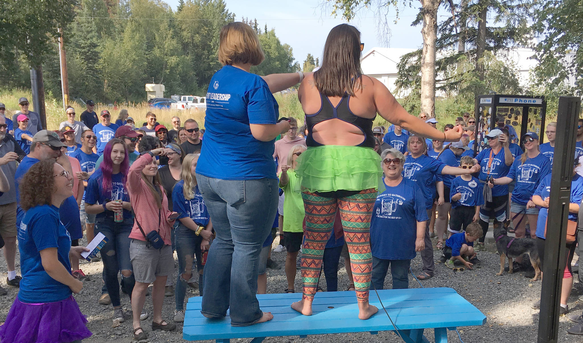 Johna Beech and Nicole Murphy warm up runners before the Brewery to Bathroom .5K “The race for the rest of us” on Sunday, Aug. 11, 2019, in Soldotna, Alaska. (Photo by Jeff Helminiak/Peninsula Clarion)