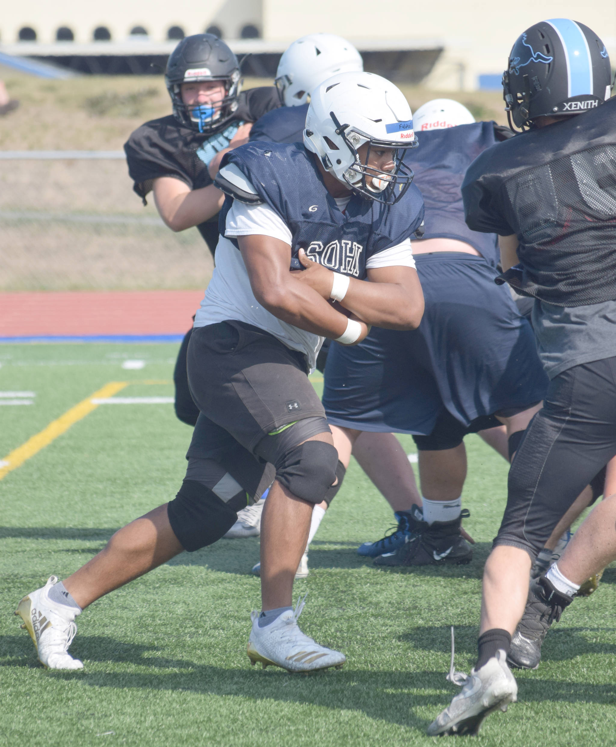 Soldotna’s Aaron Faletoi does a great job concealing the ball as he runs in a scrimmage against Chugiak on Saturday, Aug. 10, 2019, at Justin Maile Field in Soldotna, Alaska. (Photo by Jeff Helminiak/Peninsula Clarion)
