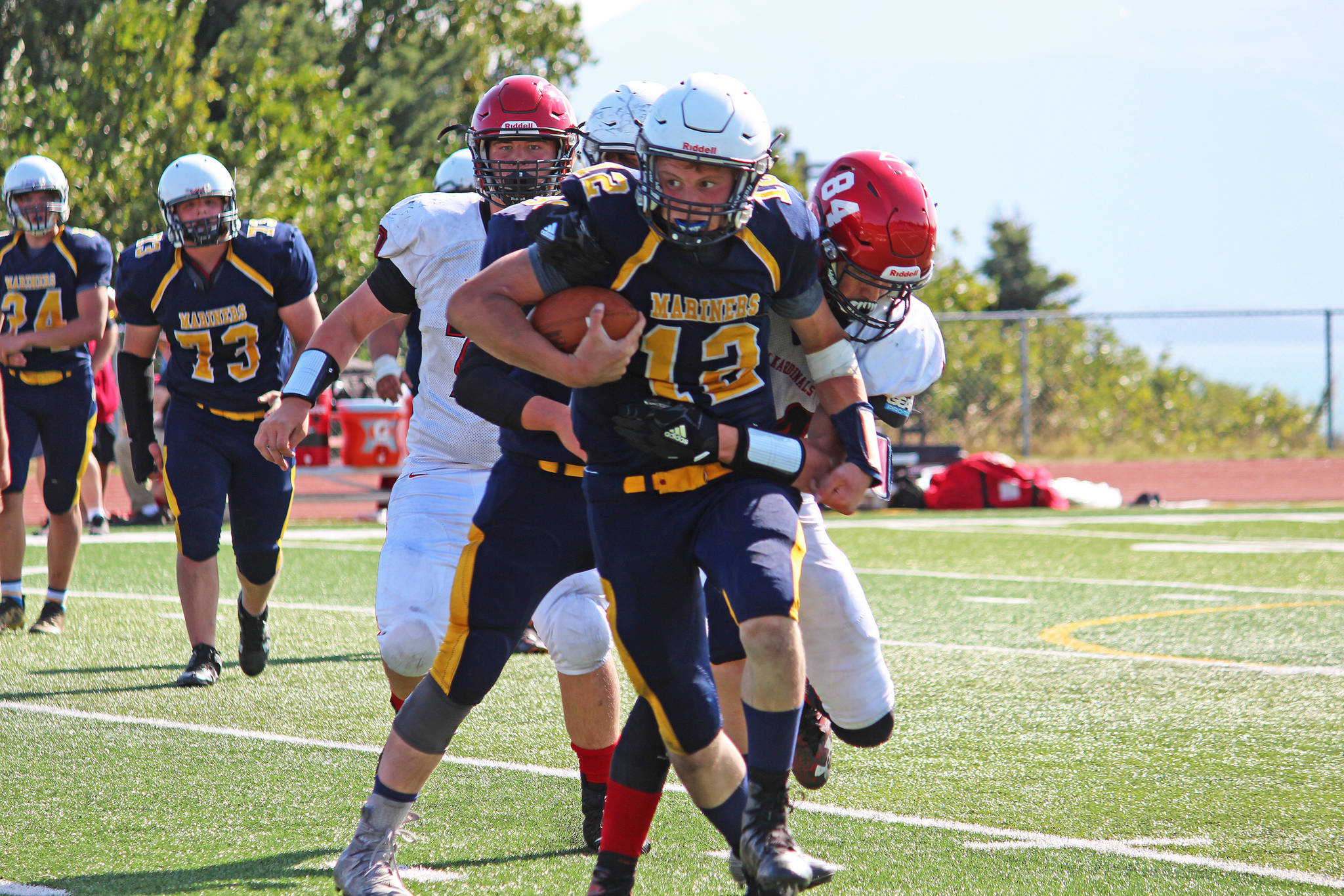 Voznesenka senior and Homer quarterback Anthony Kalugin resists Kenai tackler Aiden Milburn during a Saturday, Aug. 17, 2019 football game between the Mariners and Kardinals in Homer, Alaska. (Photo by Megan Pacer/Homer News)