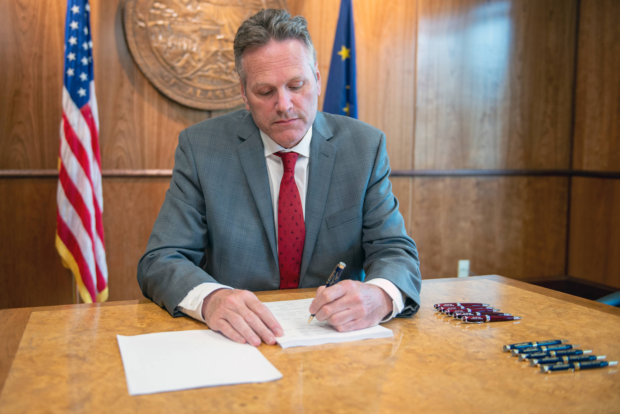 Gov. Mike Dunleavy signs House Bill 2001 at his office in Anchorage on Monday, August 19, 2019. (Courtesy photo)