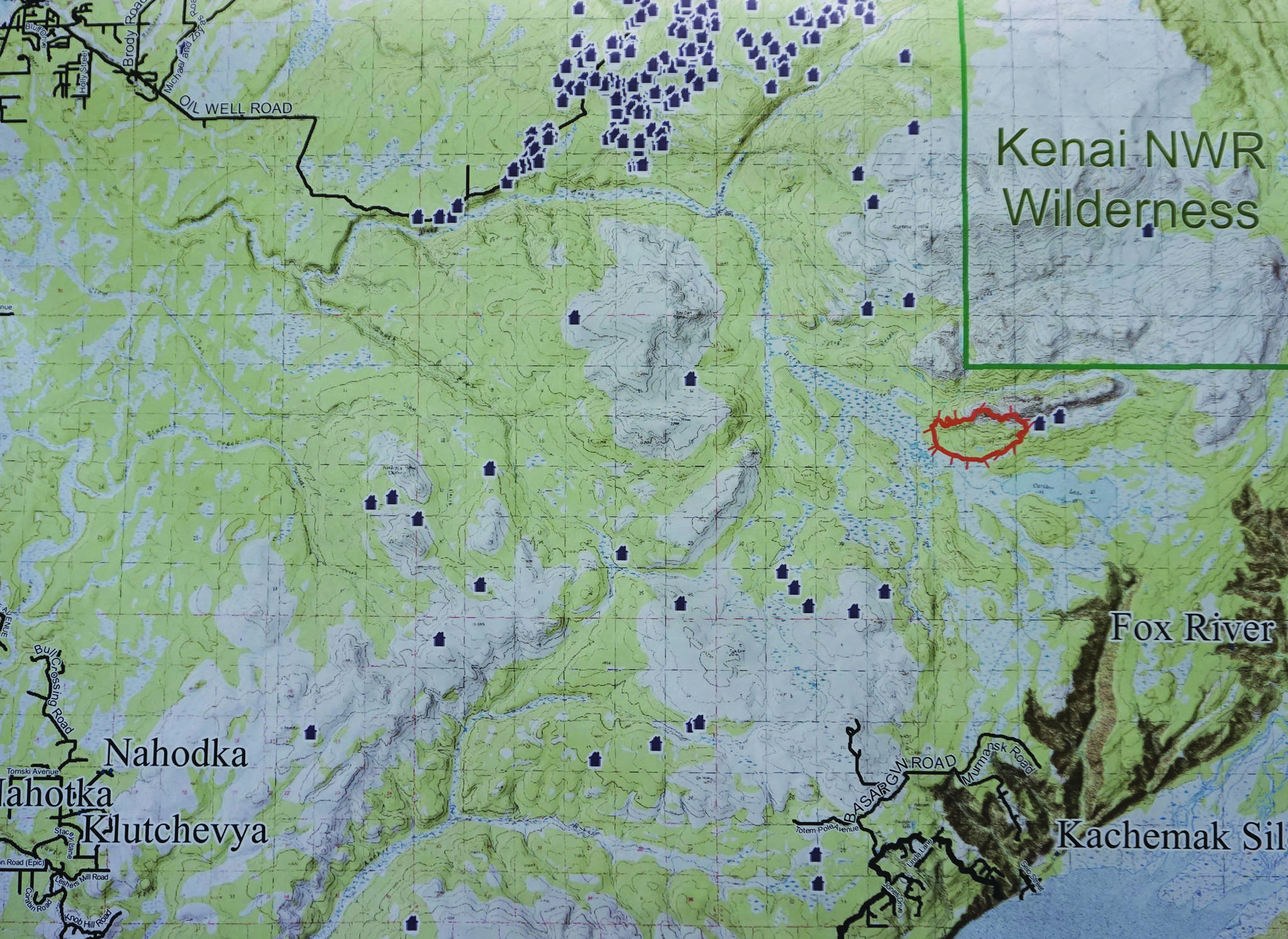 A map shows the Caribou Lake Fire, in red, in relationship to nearby communities and cabins. It was part of a community meeting held on Saturday, Aug. 24, 2019, at a McNeil Canyon Elementary School near Fritz Creek, Alaska. (Photo by Michael Armstrong/Homer News)