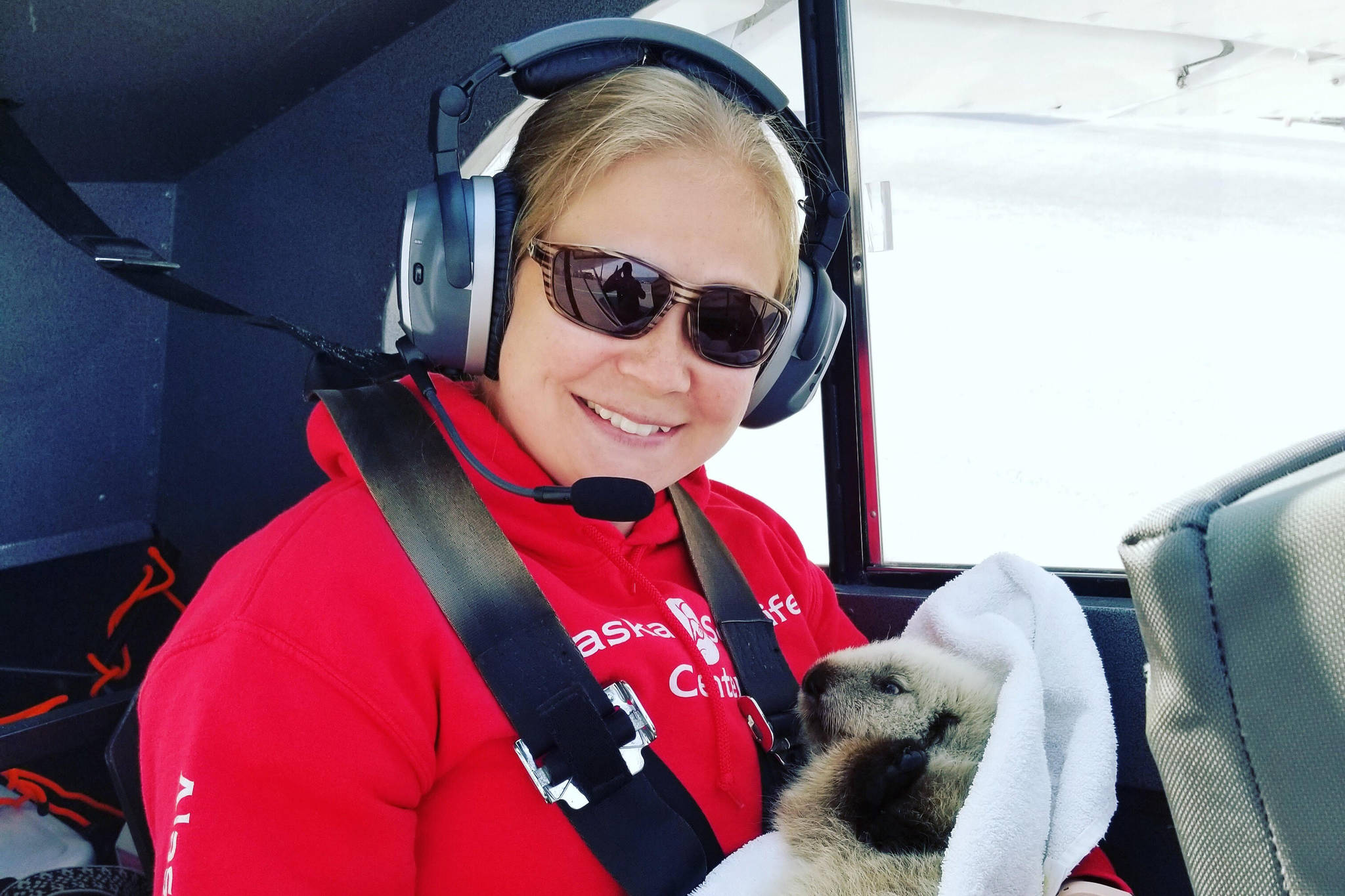 Veterinary Technician Sarah McMillen returns with the sea otter pup in Homer, Alaska, pilot, Duke Marolfs, plane. (Photo courtesy Alaska SeaLife Center)