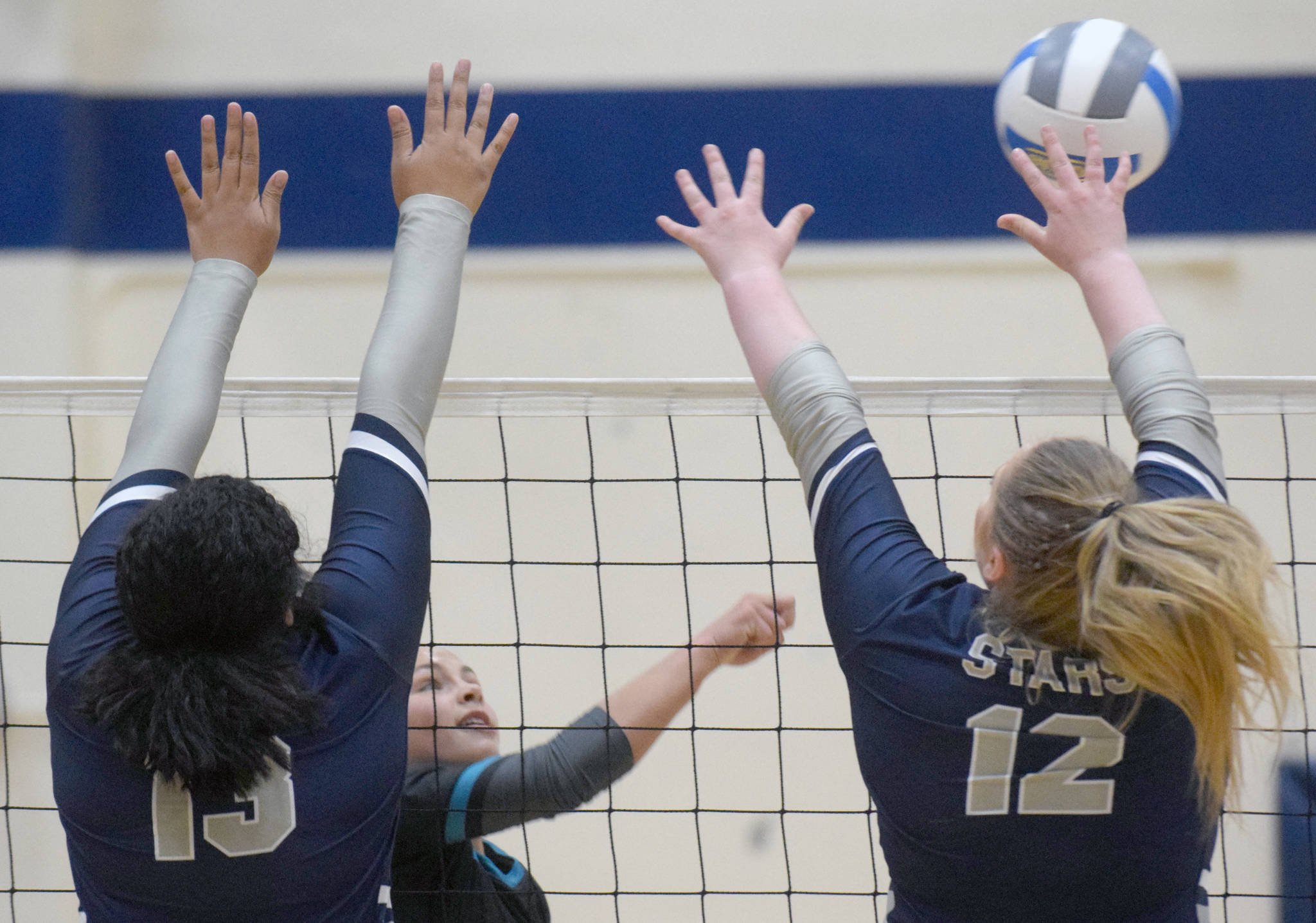 Nikiski’s Kaitlyn Johnson finds a way around the block of Soldotna’s Ituau Tuisaula and Bailey Armstrong on Thursday, Aug. 29, 2019, at Soldotna High School in Soldotna, Alaska. (Photo by Jeff Helminiak/Peninsula Clarion)