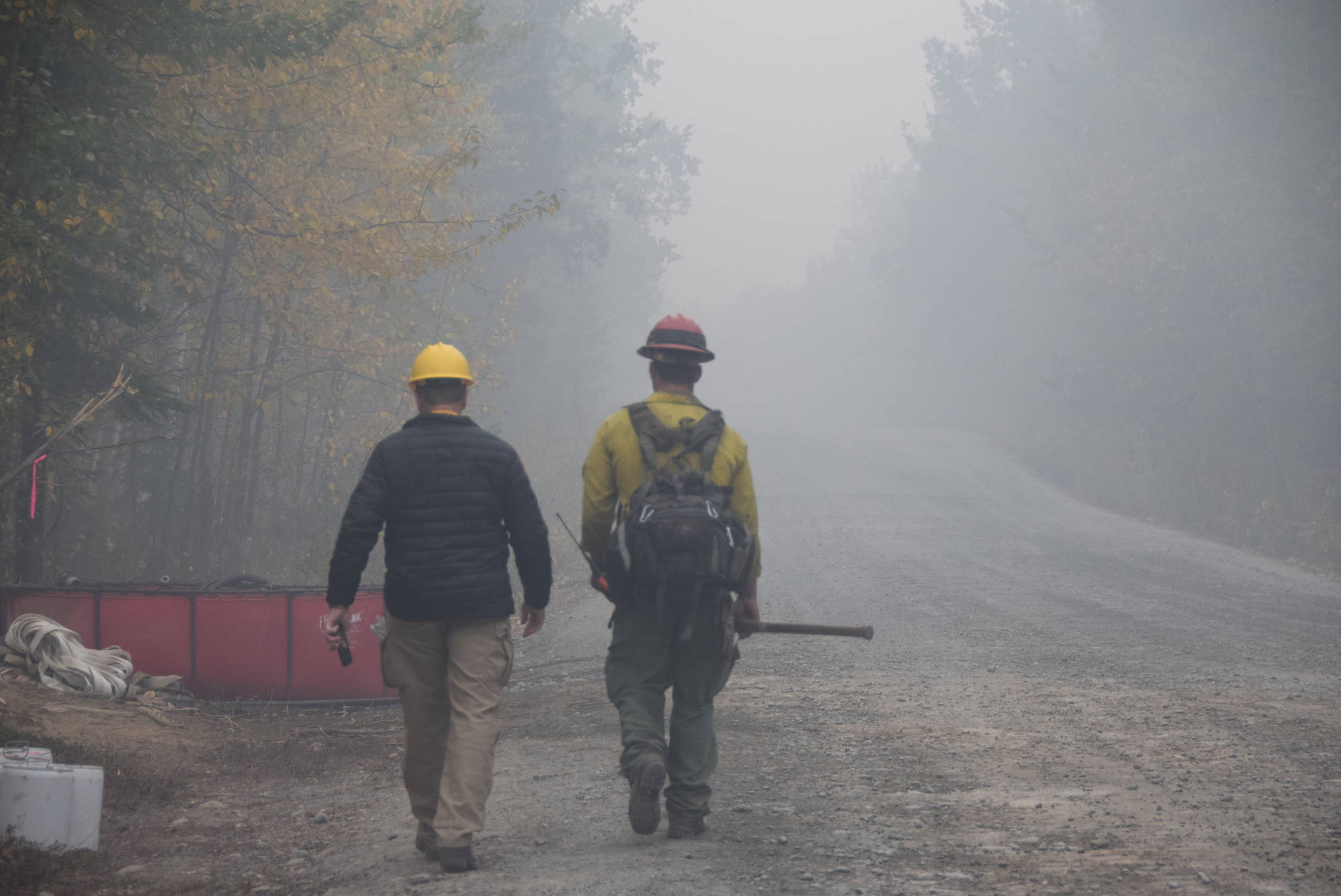 Public information officer Brian Scott, left, and Division Charlie supervisor Kip Shields, right, make their way to the nearest drop point on Skilak Lake Road on Aug. 30, 2019. (Photo by Brian Mazurek/Peninsula Clarion)