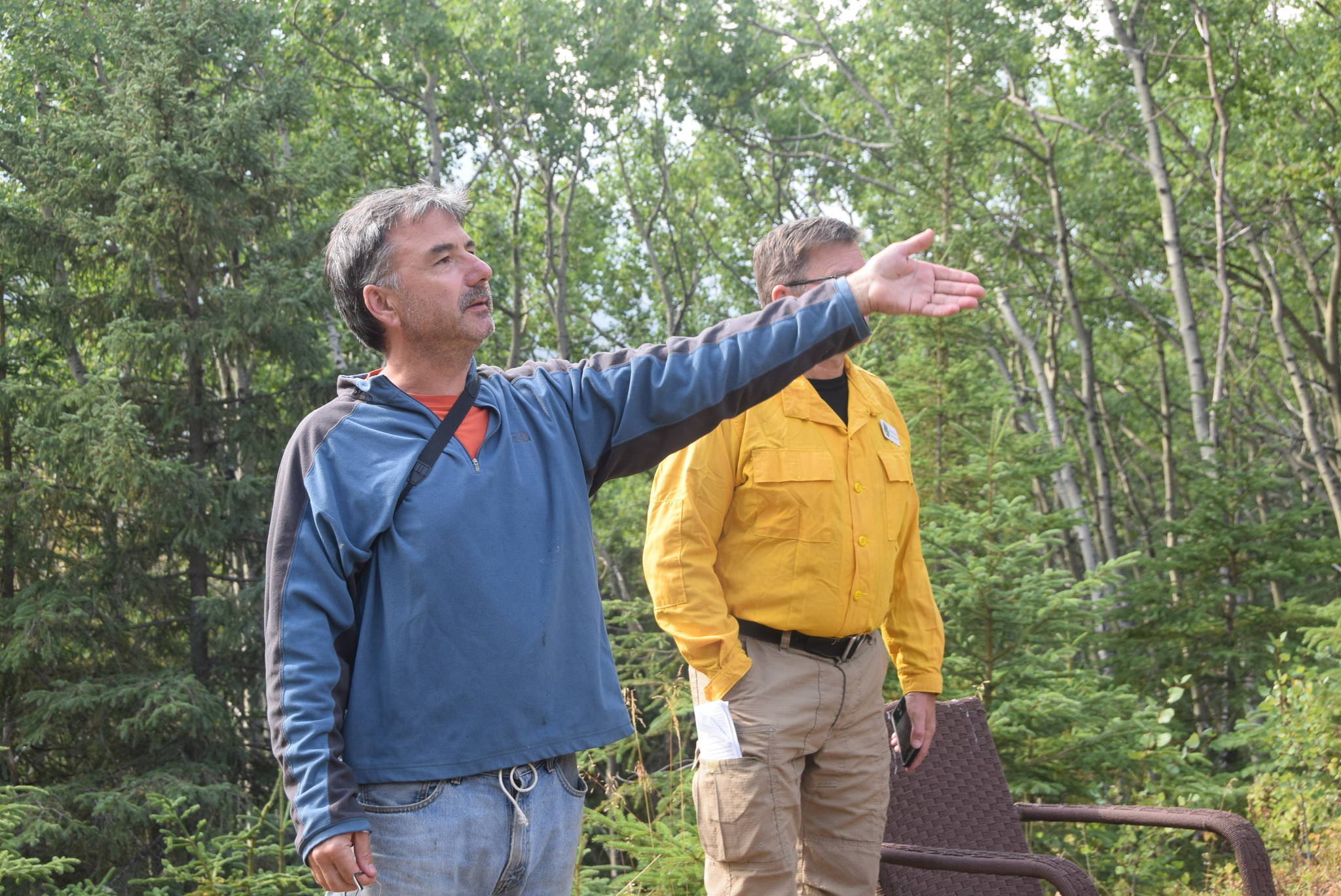 Cooper Landing homeowner Michael Link shows public information officer Brian Scott the structure protection in place around his home in Cooper Landing, Alaska on Aug. 20, 2019. (Photo by Brian Mazurek/Peninsula Clarion)