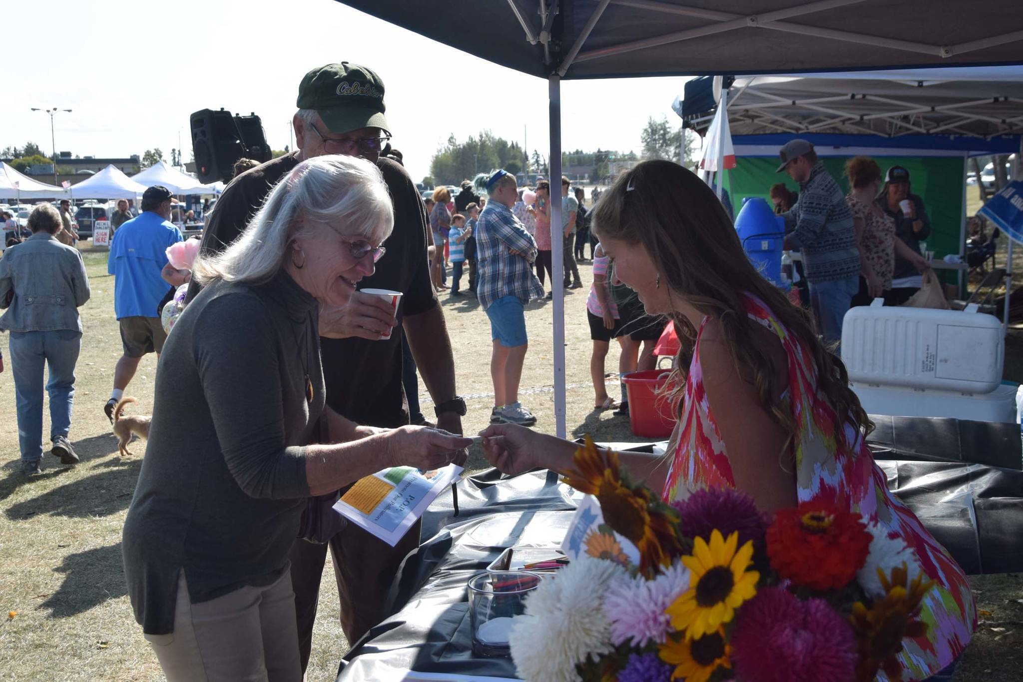 Anna Devolld, right, presents her Promote Our Pollinators project to attendees of Industry Appreciation Day at the Kenai Park Strip in Kenai, Alaska on Aug. 24, 2019. (Photo by Brian Mazurek/Peninsula Clarion)