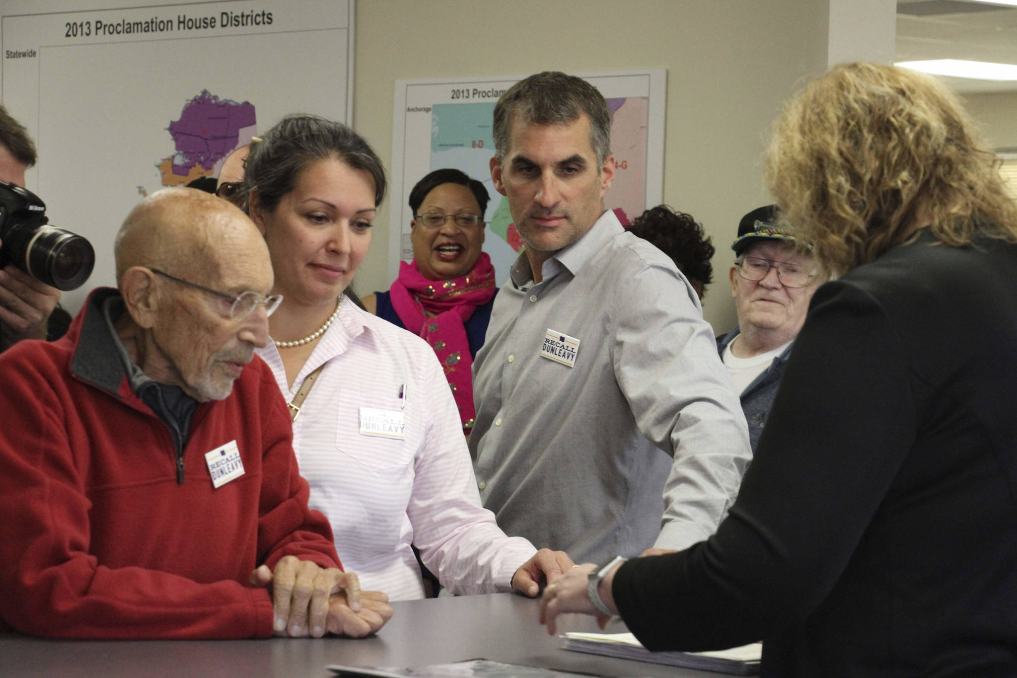 Vic Fischer, left, Meda DeWitt, middle, and Aaron Welterlen, leaders of an effort to recall Alaska Gov. Mike Dunleavy, are shown awaiting paperwork at the Alaska Division of Elections office in Anchorage, Alaska, on Thursday, Sept. 5, 2019. Recall organizers say they submitted 49,0006 signatures in in an attempt to force the recall election of the first-term governor. (AP Photo/Mark Thiessen)