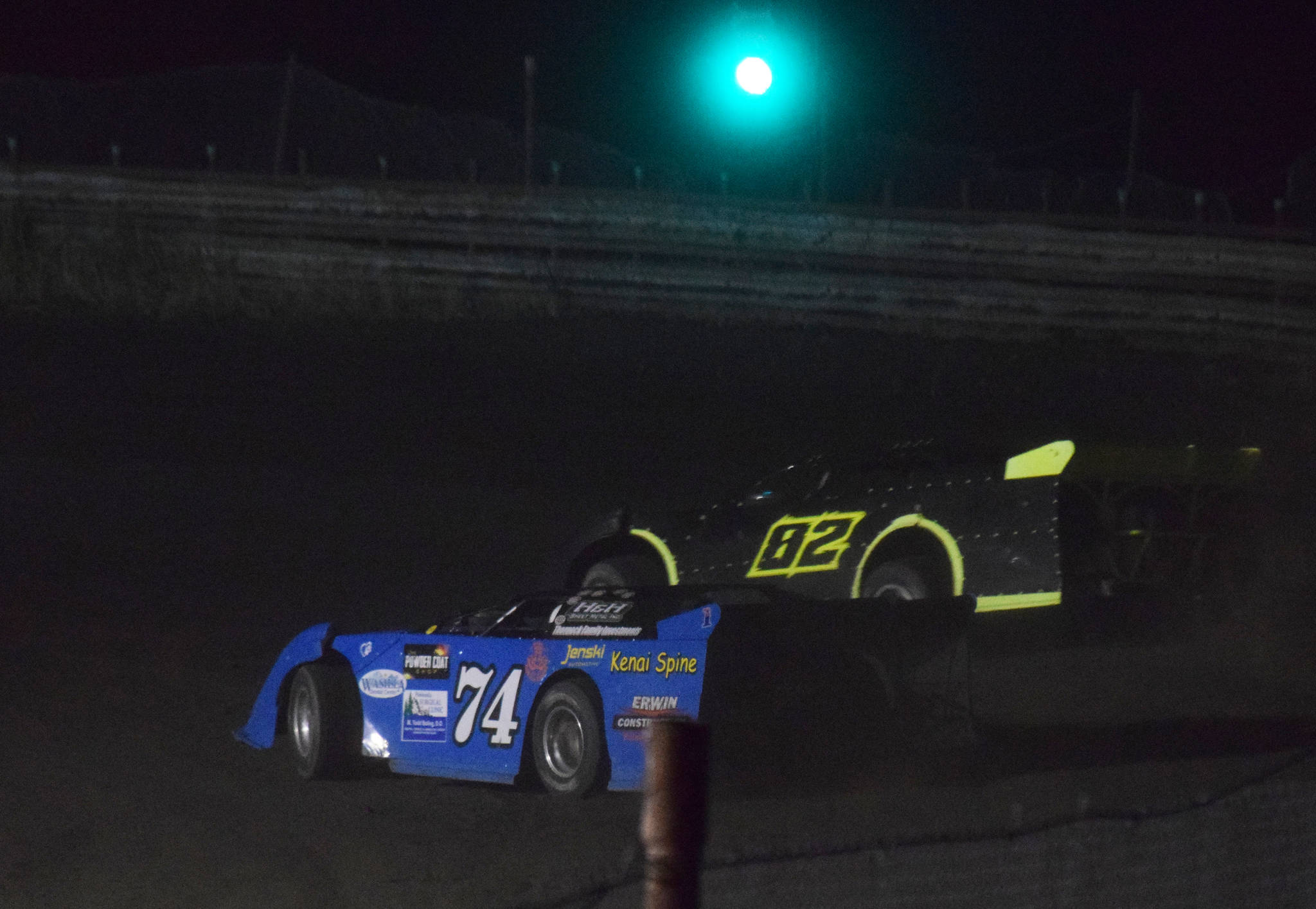 Al Ulman (74) races Mike Braddock for the lead late in Friday’s night race feature, Sept. 6, 2019, at Twin City Raceway in Kenai, Alaska. (Photo by Joey Klecka/Peninsula Clarion)