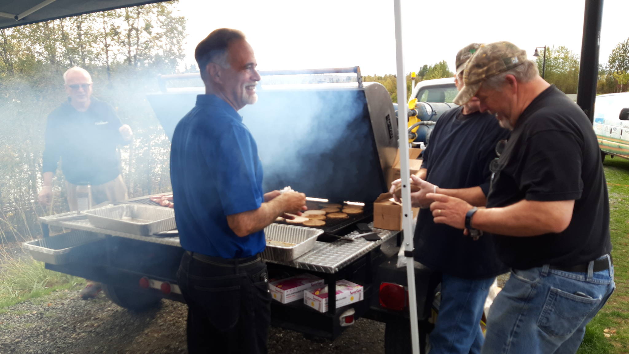 Sen. Peter Micciche, R-Soldotna, mans the grill with other volunteers during the first responder appreciation barbecue at Soldotna Creek Park on Monday, Sept. 9, 2019 in Soldotna, Alaska. (Photo by Brian Mazurek/Peninsula Clarion)