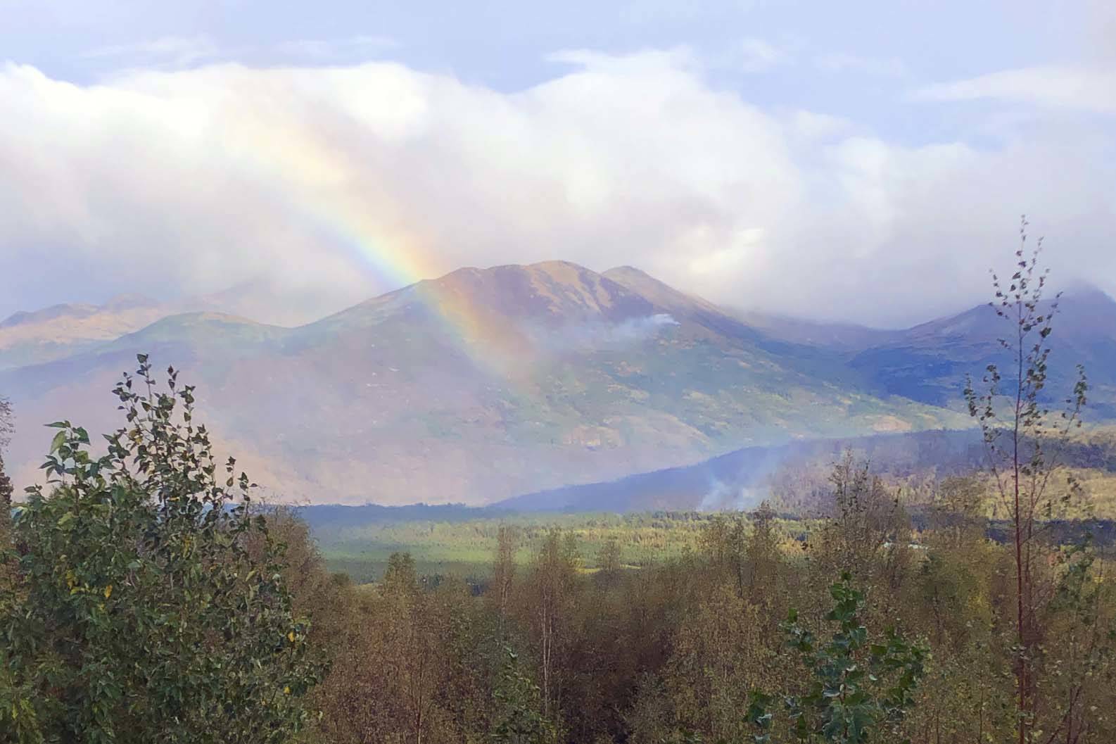 Courtesy Kenai Peninsula Borough Office of Emergency Management                                A rainbow can be seen next to rising smoke from the Swan Lake Fire in this photo released Thursday, Sept. 5.