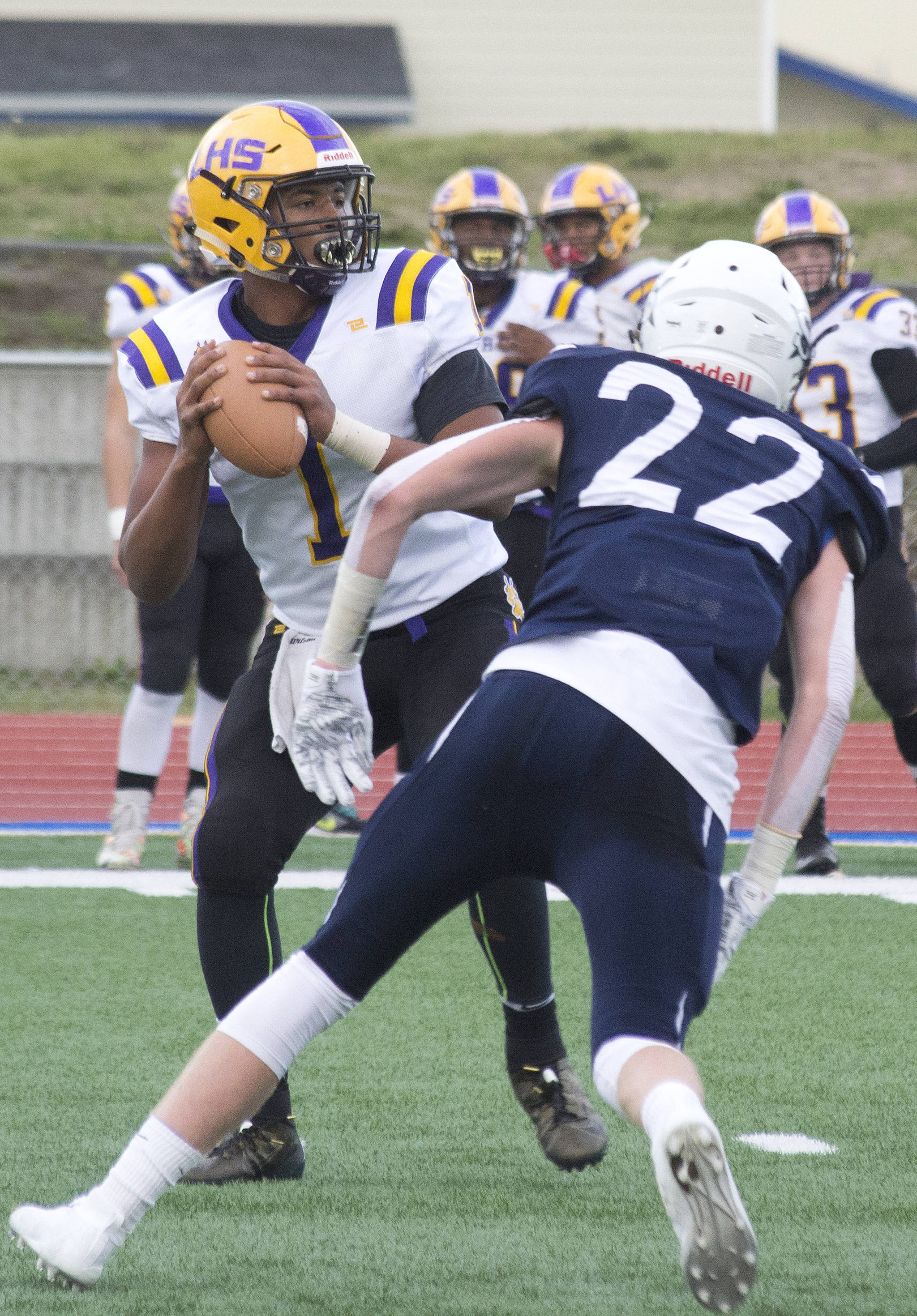 Lathrop quarterback Jace Henry looks for an open receiver against the onrushing Ray Chumley (22) Friday, Sept. 13, 2019, at Justin Maile Field in Soldotna, Alaska. (Photo by Joey Klecka/Peninsula Clarion)