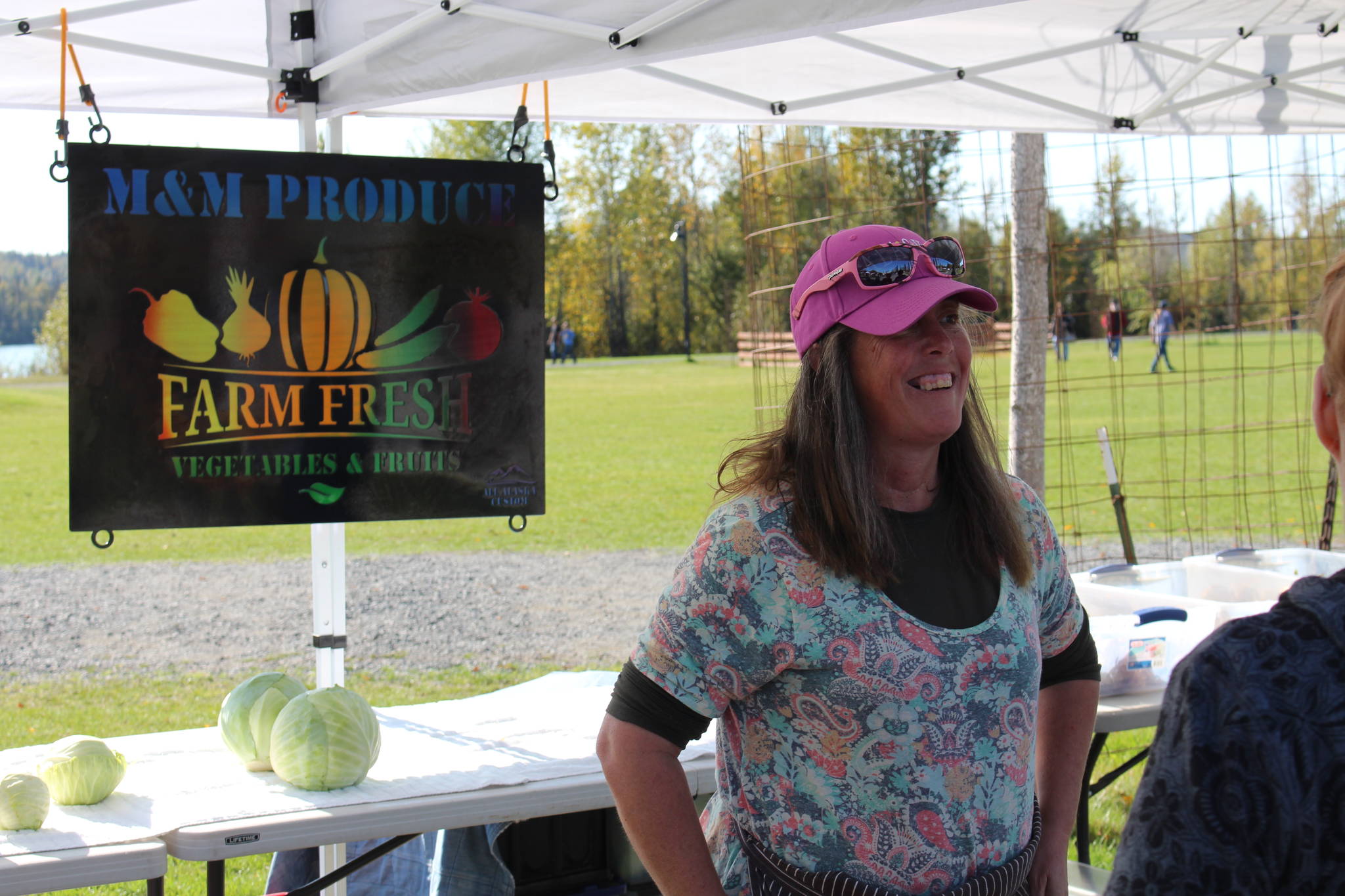 Mary Appelhanz of M&M Produce speaks to customers at the Harvest Moon Local Food Festival at Soldotna Creek Park on Sept. 14, 2019. (Photo by Brian Mazurek/Peninsula Clarion)