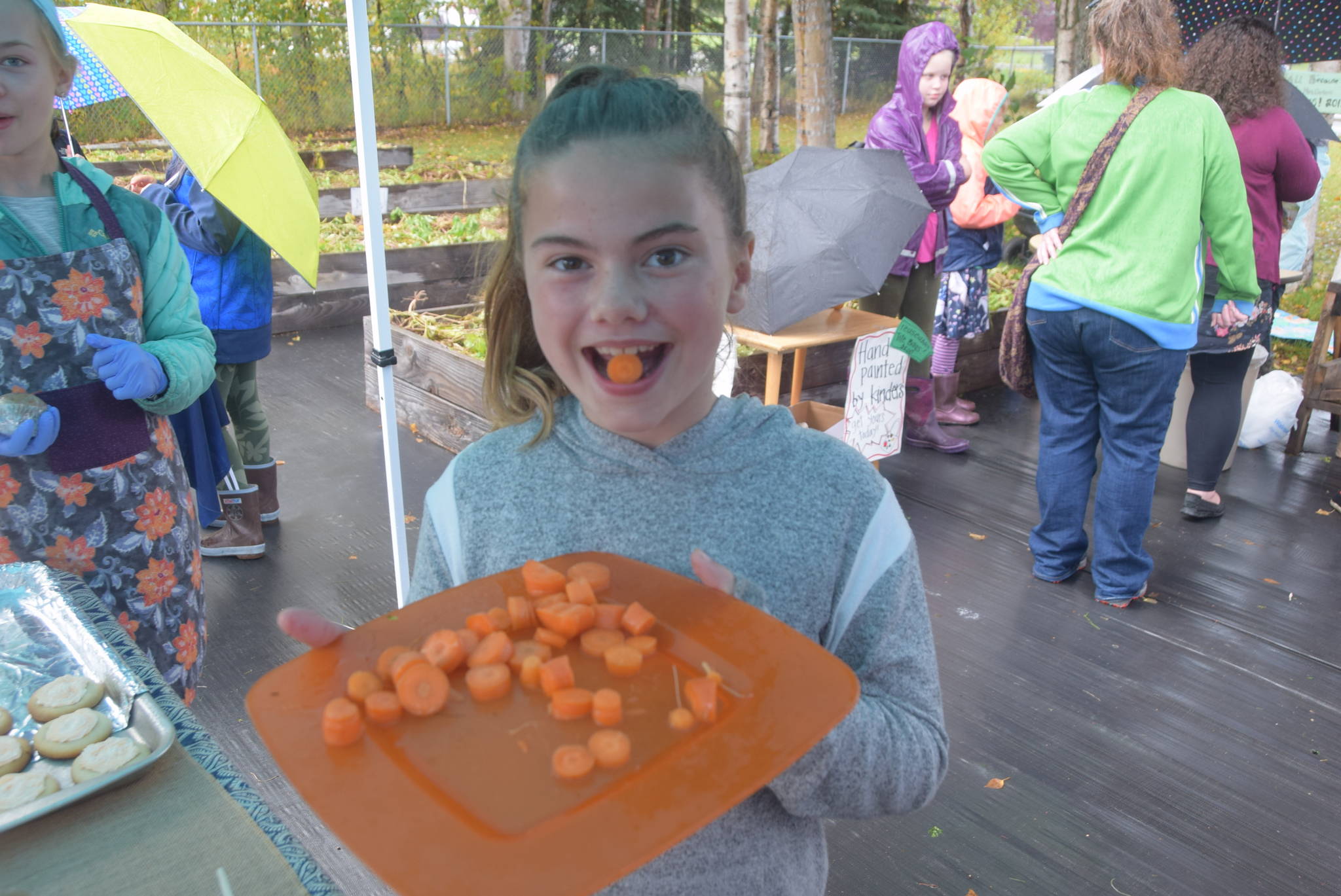 Fourth grader Shea Linton hands out free carrot samples at the Montessori Farmer’s Market at the Soldotna Montessori School on Sept. 13, 2019. (Photo by Brian Mazurek/Peninsula Clarion)