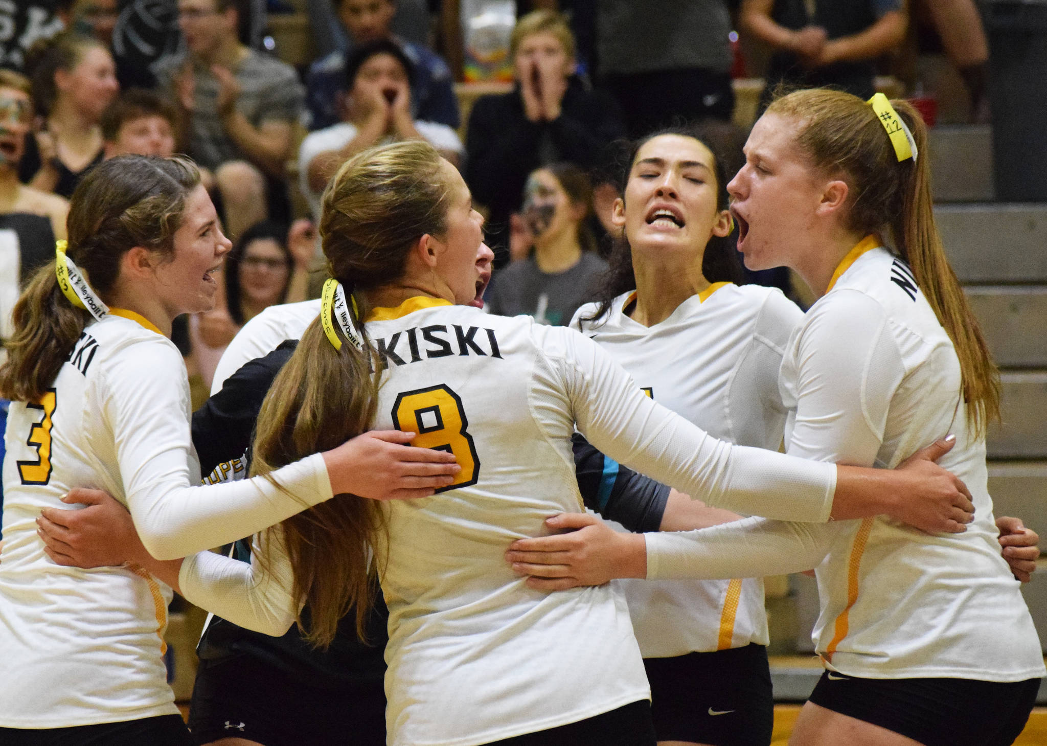 Nikiski seniors Kaycee Bostic (right) and Tika Zimmerman encourage the team, Tuesday, Sept. 17, 2019, against Kenai Central at Nikiski High School. (Photo by Joey Klecka/Peninsula Clarion)