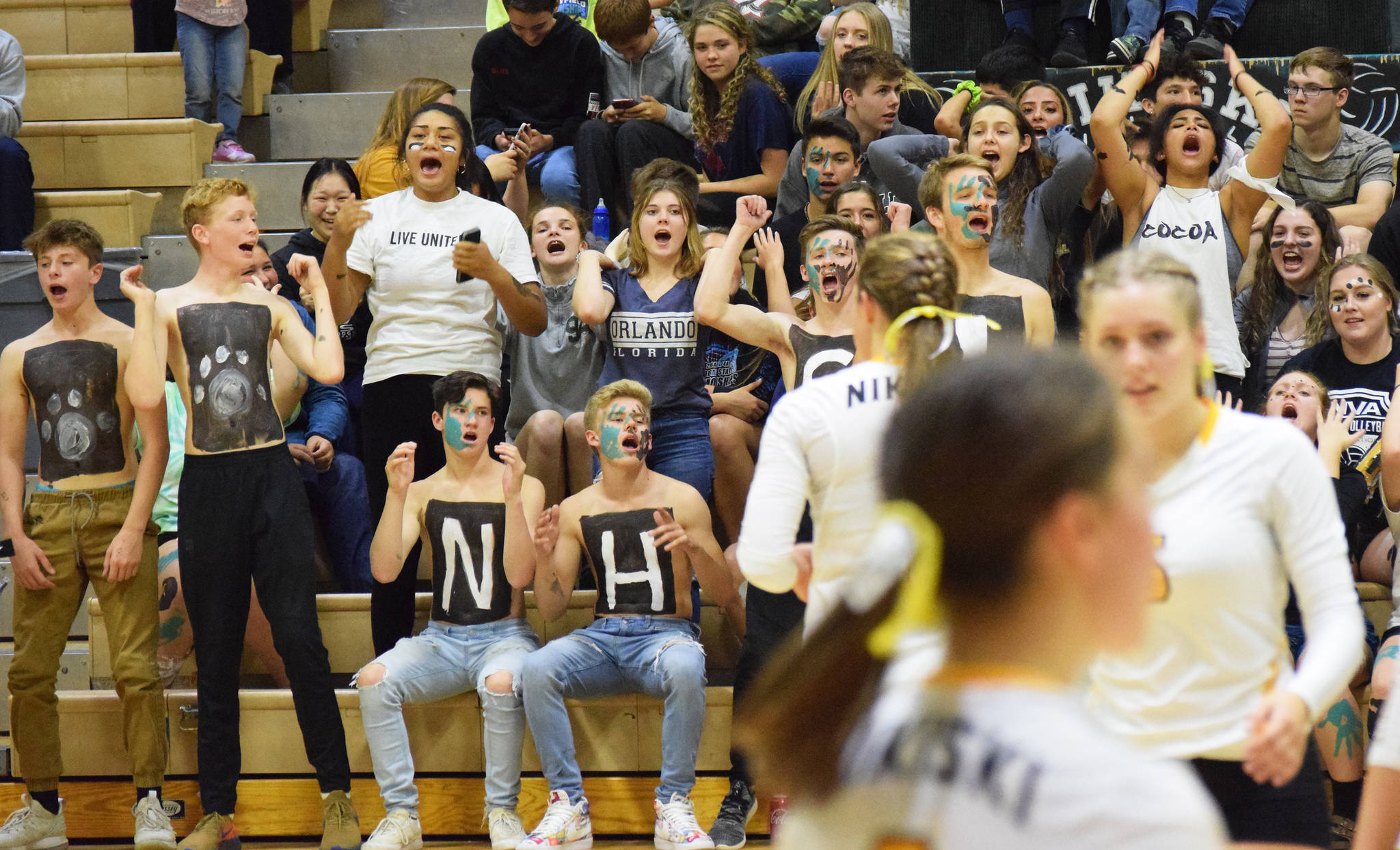 Nikiski High School students, as well as a few Soldotna High School volleyball players, cheer on the Nikiski volleyball team Tuesday, Sept. 17, 2019, against Kenai Central at Nikiski High School. (Photo by Joey Klecka/Peninsula Clarion)