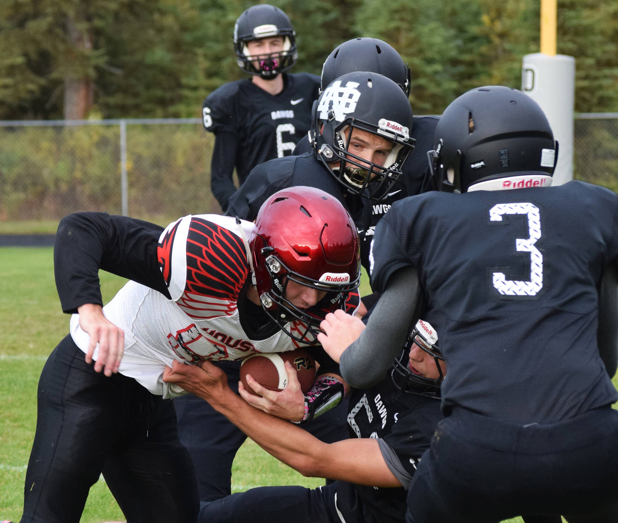 Houston’s Gavin Mulhaney is swarmed by a pack of Nikiski defenders Friday, Sept. 20, 2019, at Nikiski High School. (Photo by Joey Klecka/Peninsula Clarion)