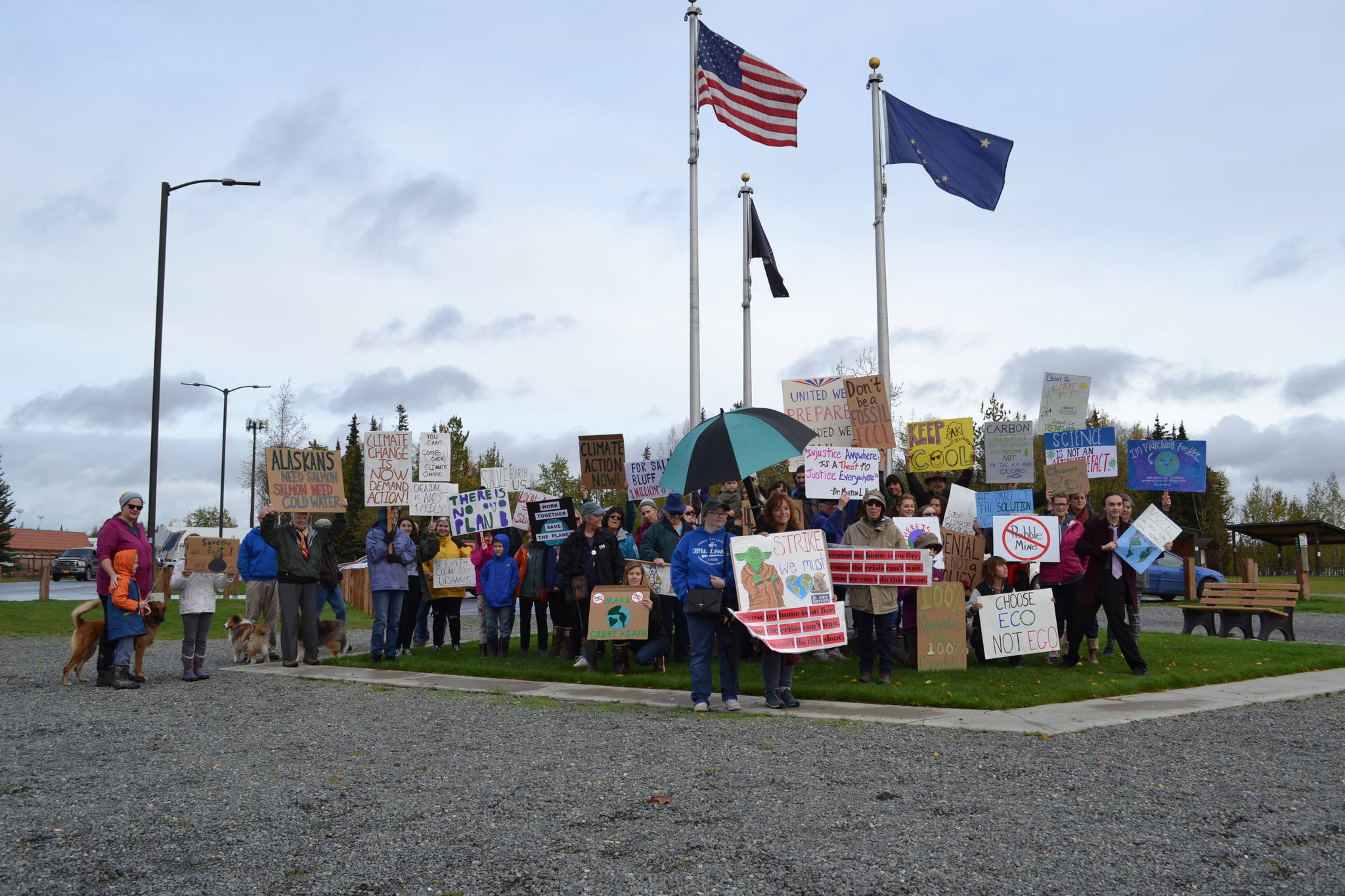 Marchers in the Soldotna Climate Strike stop for a group photo in Soldotna Creek Park on Sept. 20, 2019. (Photo by Brian Mazurek/Peninsula Clarion)