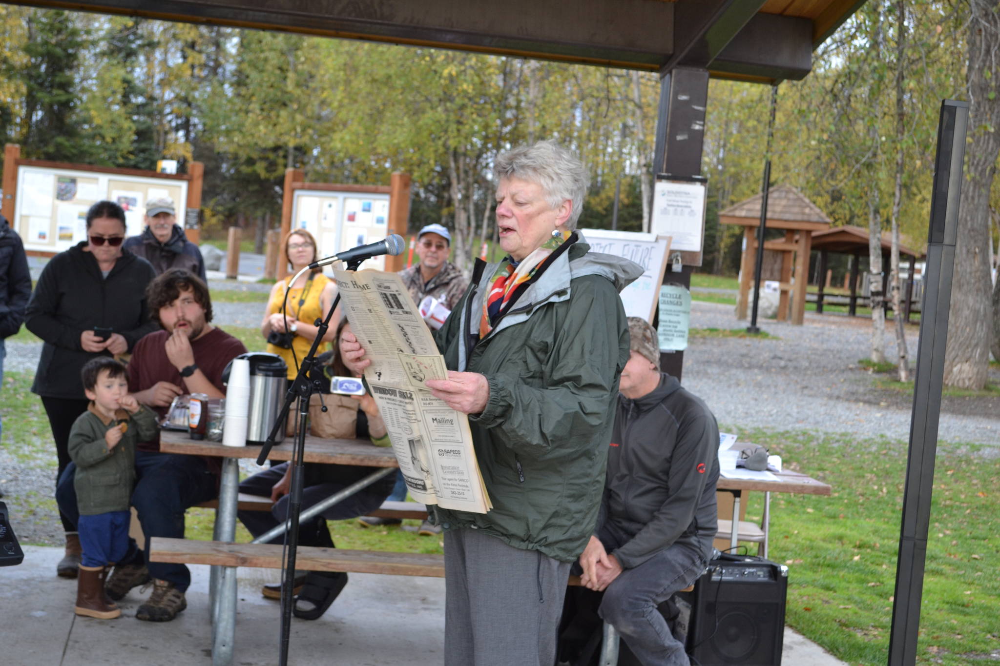 Soldotna Business Owner Peggy Mullen reads a newspaper from 1994 that warns of the negative effects of pollution at the Soldotna Climate Strike in Soldotna Creek Park on Sept. 20, 2019. (Photo by Brian Mazurek/Peninsula Clarion)