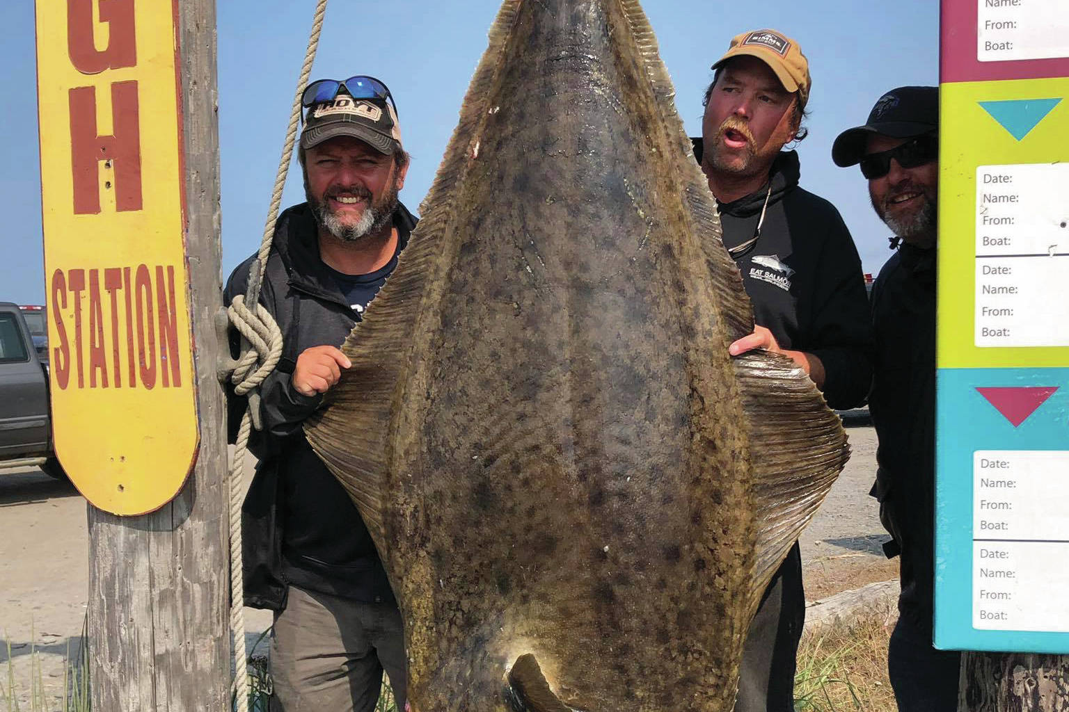 Homer Jackpot Halibut Derby winner Jason Schuler, left, of Wahpeton, North Dakota, poses with his 224.2-pound fish on July 12, 2019, in Homer, Alaska. To the right of the fish is Captain Daniel Donich of Daniel’s Personalized Guide Service. Schuler caught the fish on Donich’s boat, the Optimist. (Photo provided)