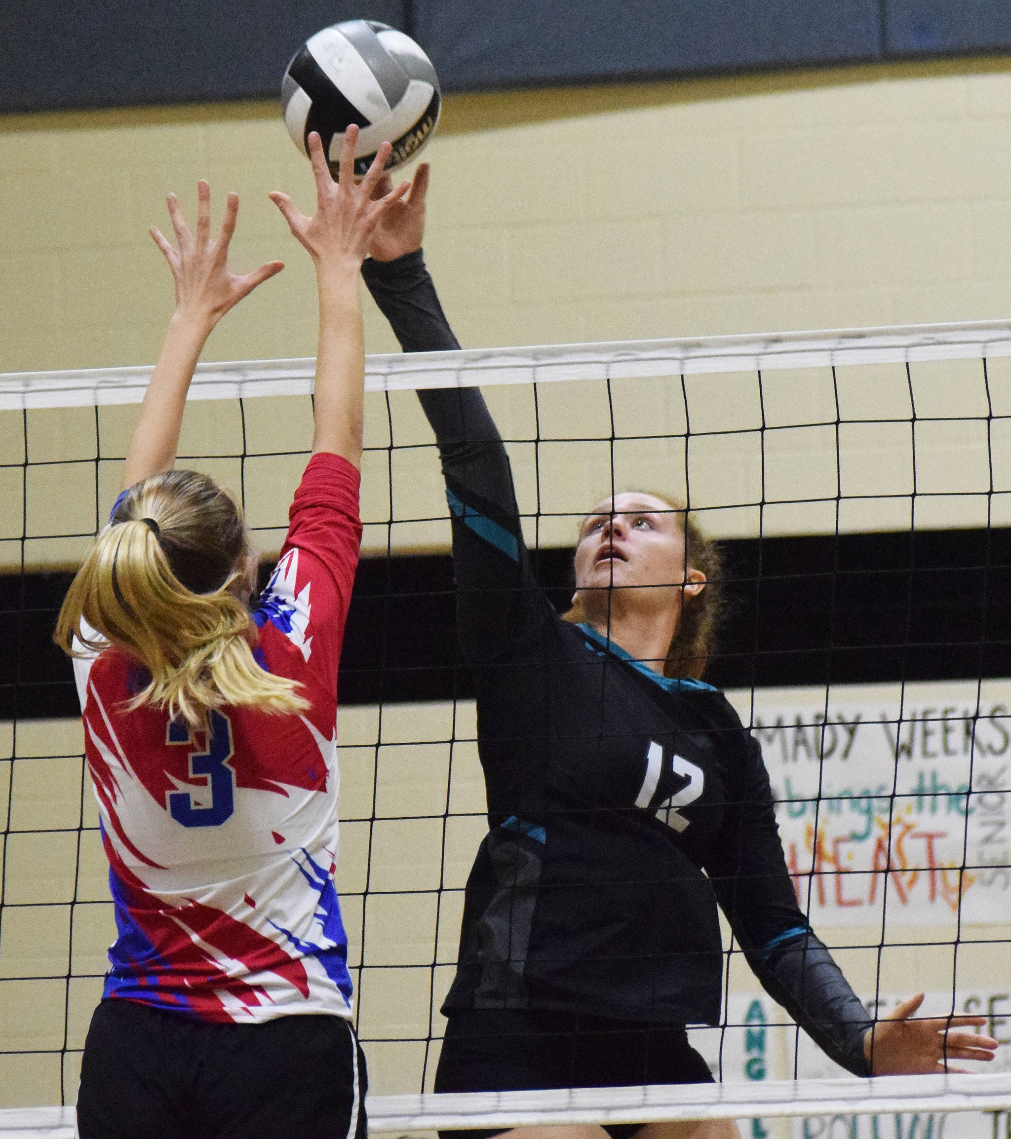 Nikiski’s Kaycee Bostic beats Anchorage Christian’s Meagan Severson to the ball Friday, Sept. 27, 2019, against ACS at Nikiski High School. (Photo by Joey Klecka/Peninsula Clarion)