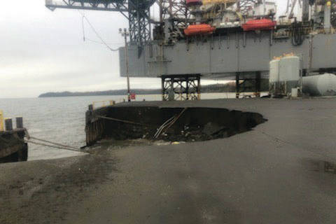 Heavy seas caused an Offshore System Kenai (OSK) earth and fill dock, with fuel lines, to collapse, Wednesday, resulting in the discharge of approximately 300 gallons of oil. Inspectors from Coast Guard Marine Safety Detachment Homer responded to the incident and are coordinating with the responsible party and state authorities to mitigate further pollution. The dock continues to erode, but all remaining hazardous materials have been removed. (U.S. Coast Guard courtesy photo)