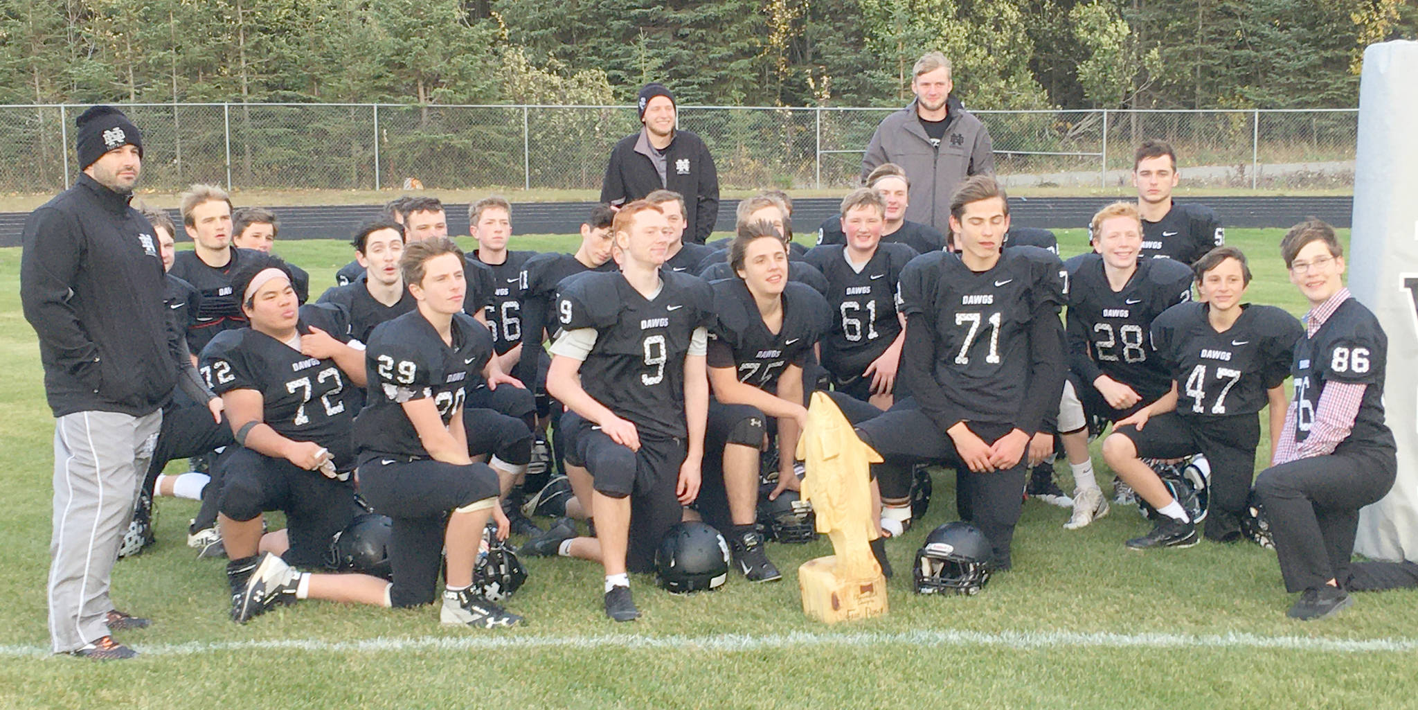 The Nikiski football team shows off the Fish Bowl trophy they won by toppling Seward on Friday at Nikiski High School in Nikiski, Alaska. (Photo by Jeff Helminiak/Peninsula Clarion)