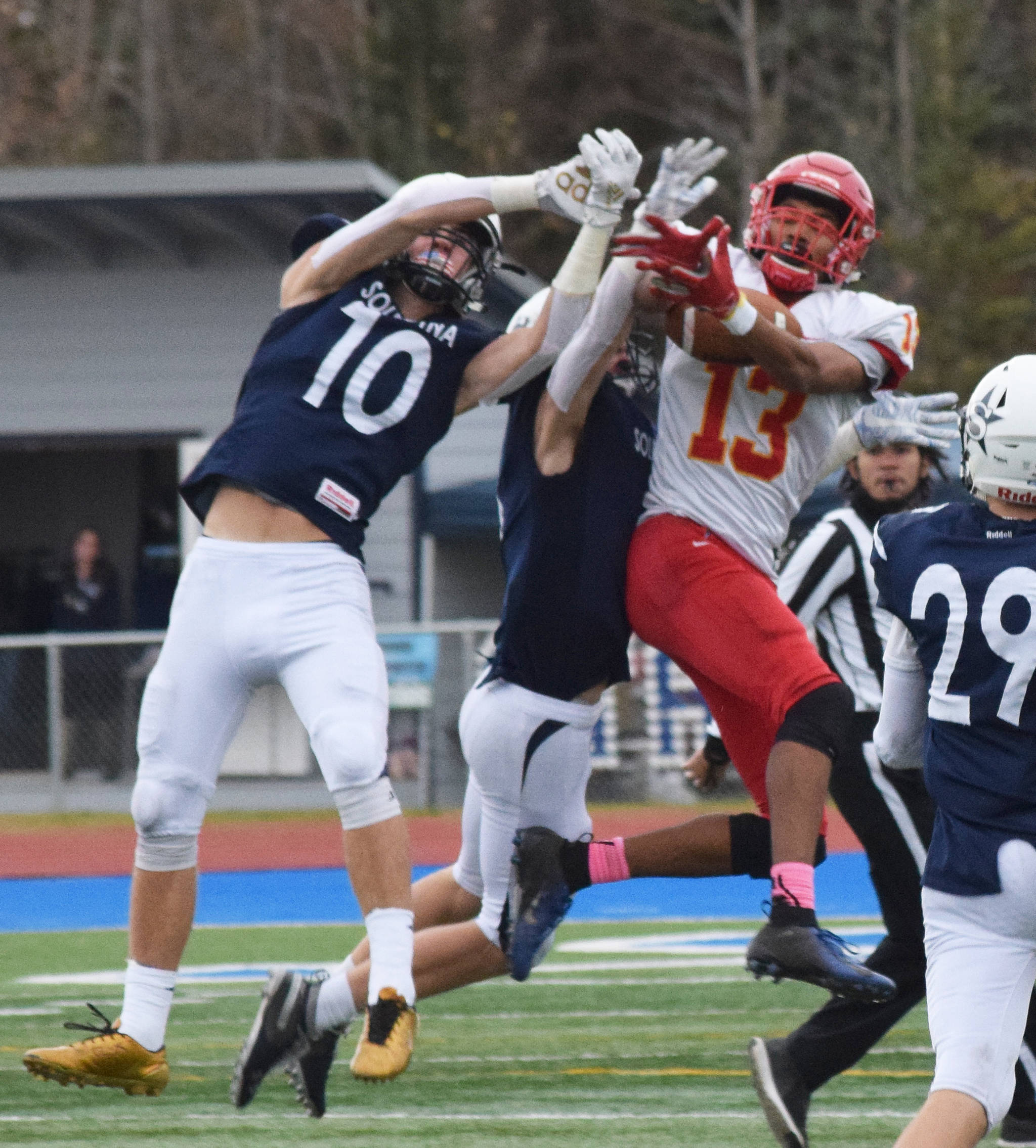 West Valley’s Tyriq Nance (13) hauls in a reception with Soldotna defenders Zach Hanson (10) and Jersey Truesdell defending in a Div. II state semifinal Friday, Oct. 11, 2019, in Soldotna, Alaska. (Photo by Joey Klecka/Peninsula Clarion)