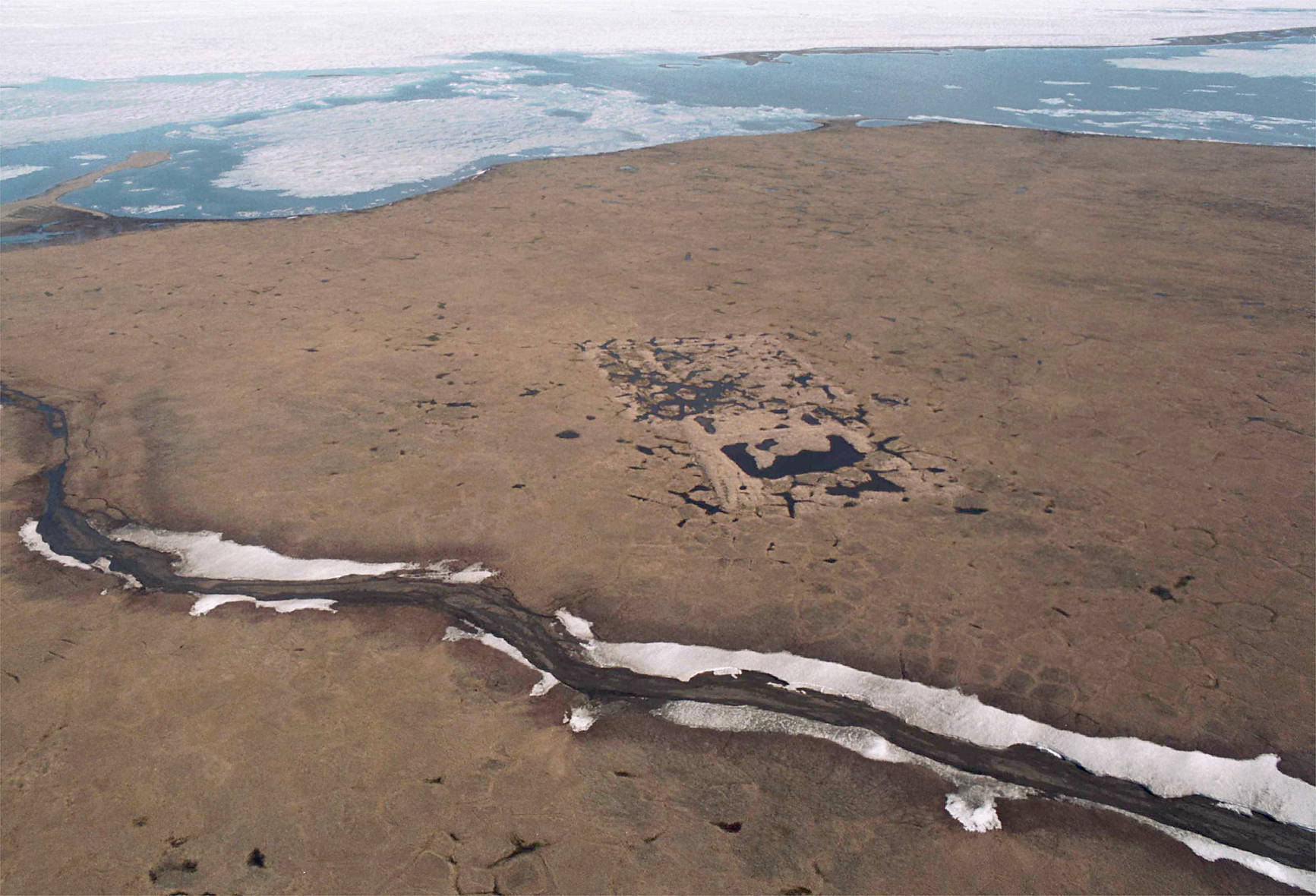 An aerial shows the footprint of the test well drilled in the mid-1980s on land owned by the Kaktovik Native village corporation within the 1002 area of the Arctic National Wildlife Refuge.(Michael Penn | Juneau Empire File)