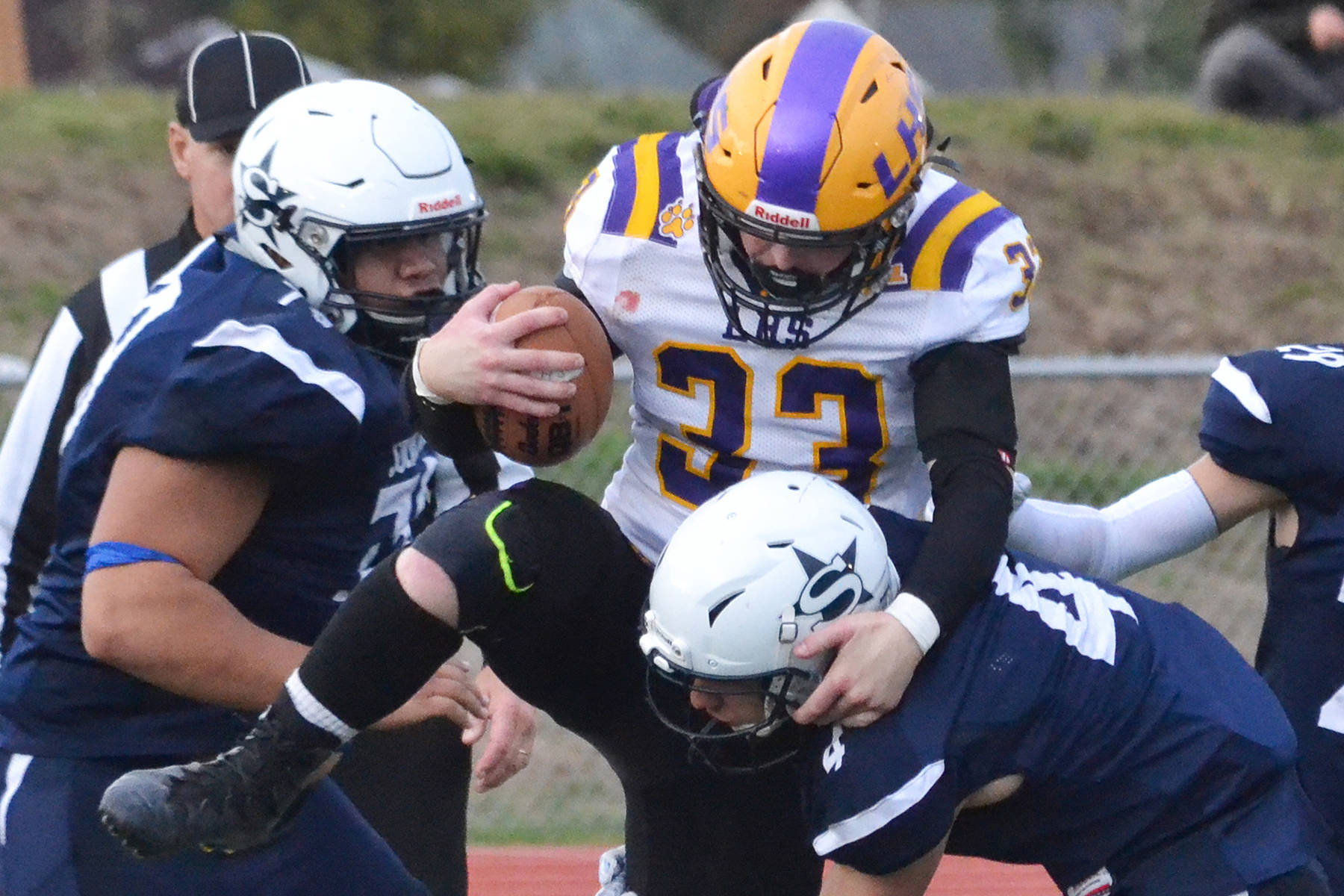 Lathrop running back Josiah Opp gets swarmed by Soldotna’s Melvin Lloyd (left) and Jersey Truesdell Friday, Sept. 13, 2019, at Justin Maile Field in Soldotna, Alaska. (Photo by Joey Klecka/Peninsula Clarion)