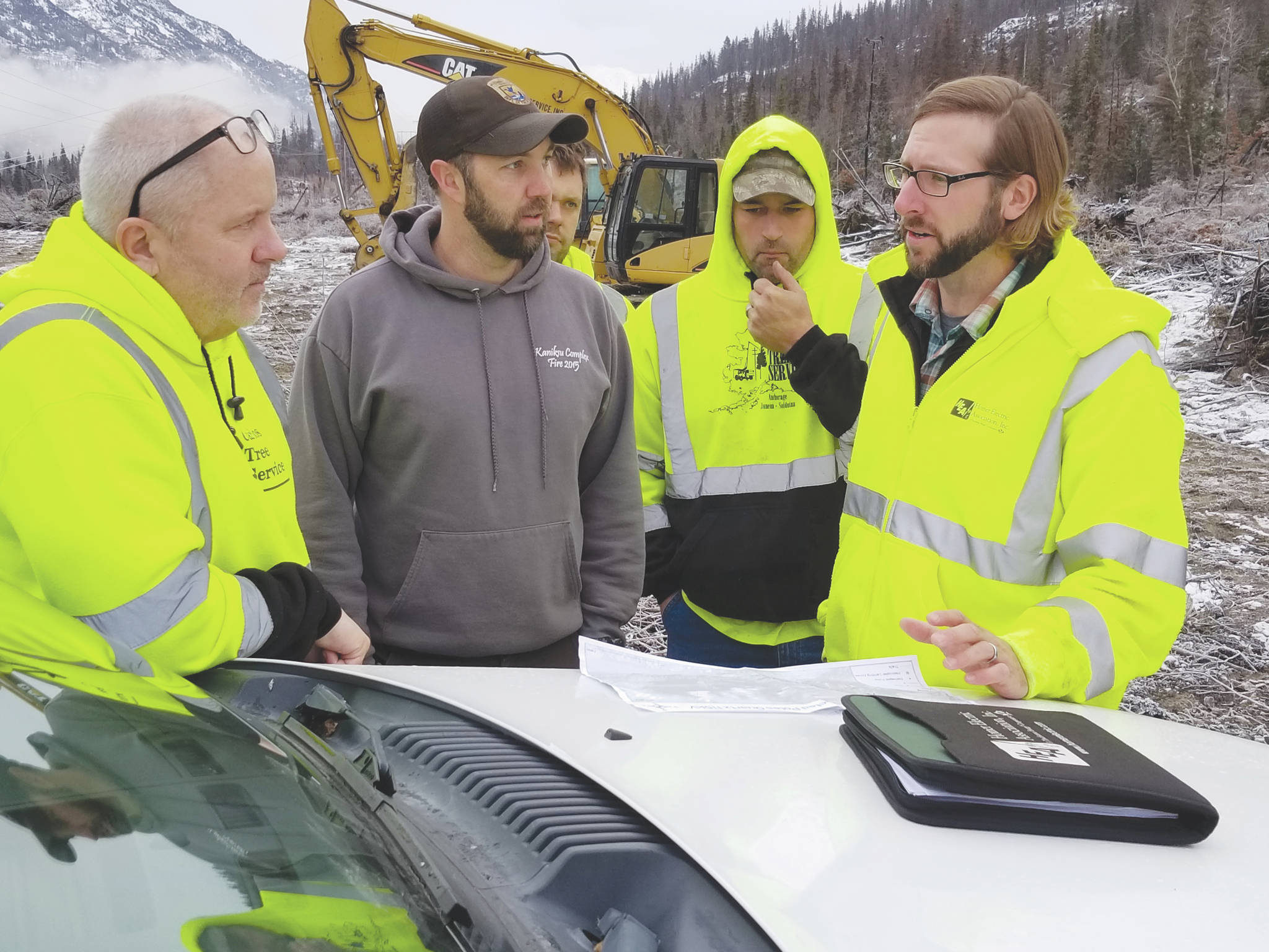 Courtesy photo                                HEA Land Management Officer Cody Neuendorf and Mike Hill, Kenai Wildlife Refuge assistant fire management officer, brief a clearing contractor on fire-related hazards at the “S/Q Line” Right of Way in this undated photo.