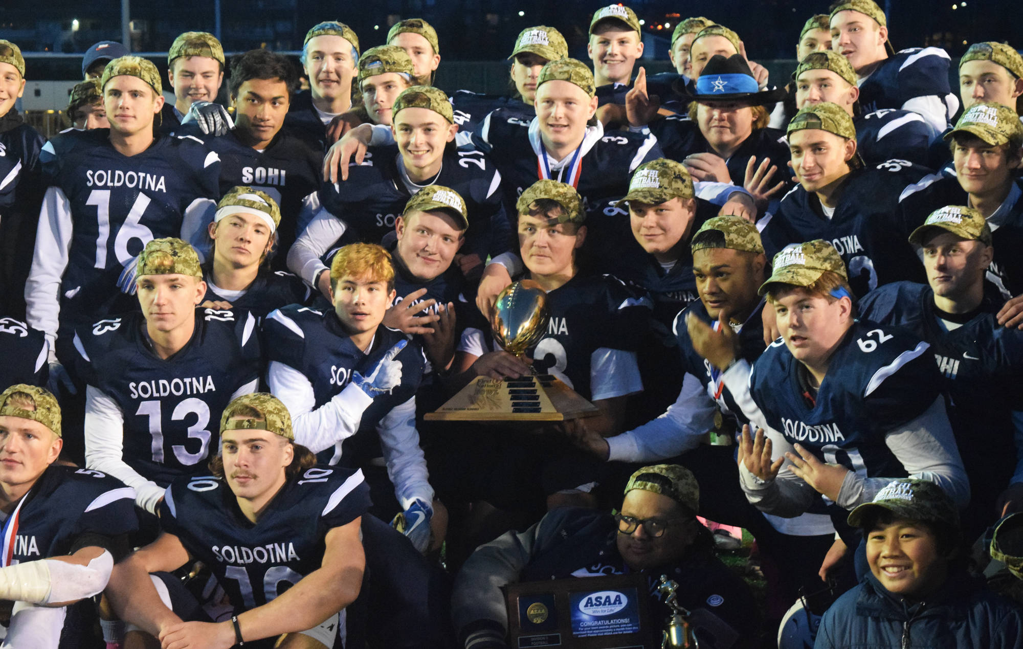 Members of the Soldotna football team pose with the trophy Saturday, Oct. 19, 2019, at the Div. II state football championship at Anchorage Football Stadium in Anchorage, Alaska. Soldotna defeated Lathrop 69-13. (Photo by Joey Klecka/Peninsula Clarion)