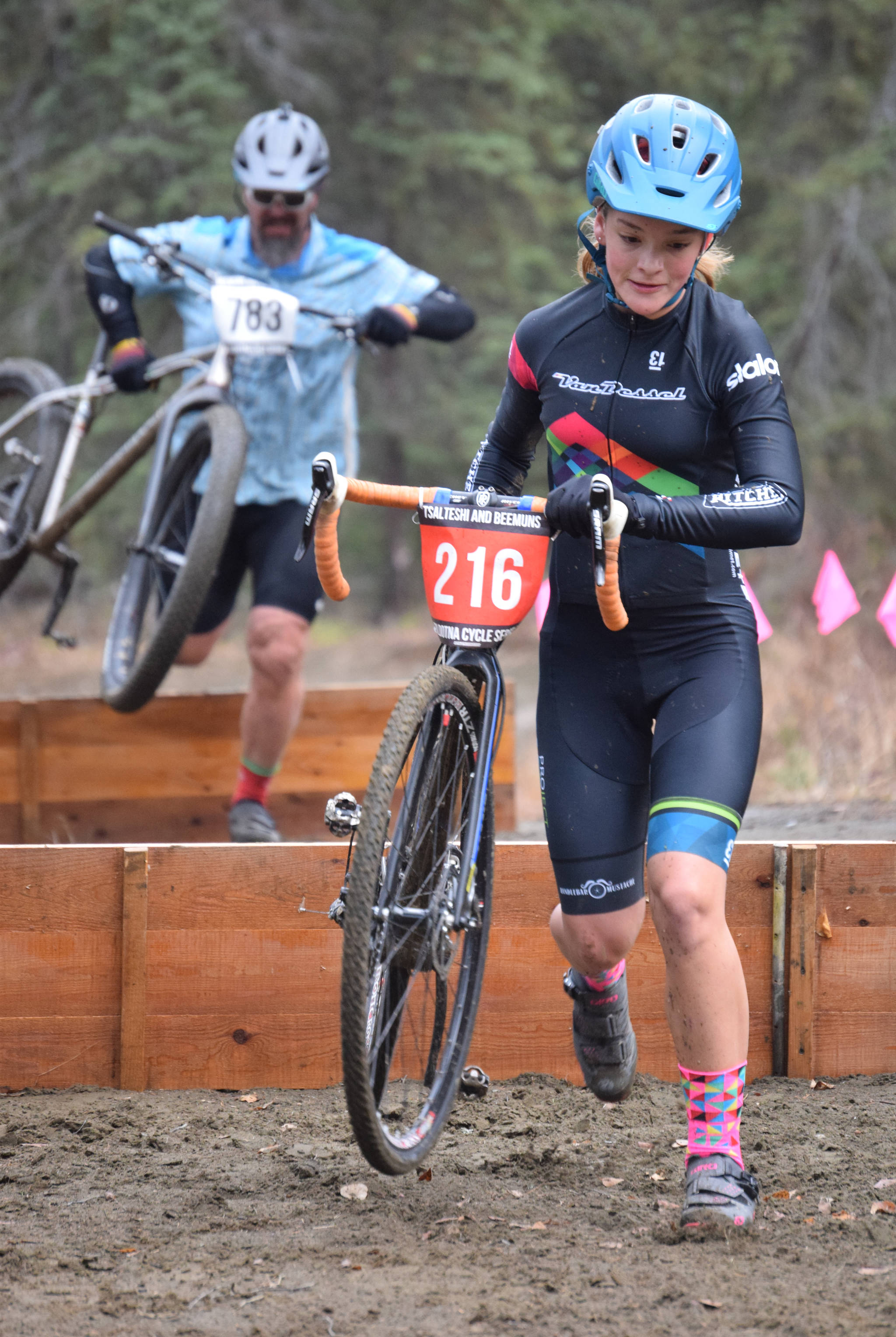 Kalima Glascott leads her father, Bob Glascott, over barriers at the Alaska Cyclocross State Championships on Saturday, Oct. 19, 2019, at Tsalteshi Trails near Soldotna, Alaska. The Glascotts are both from Anchorage. Kalima won the girls under-18 state title. (Photo by Jeff Helminiak/Peninsula Clarion)