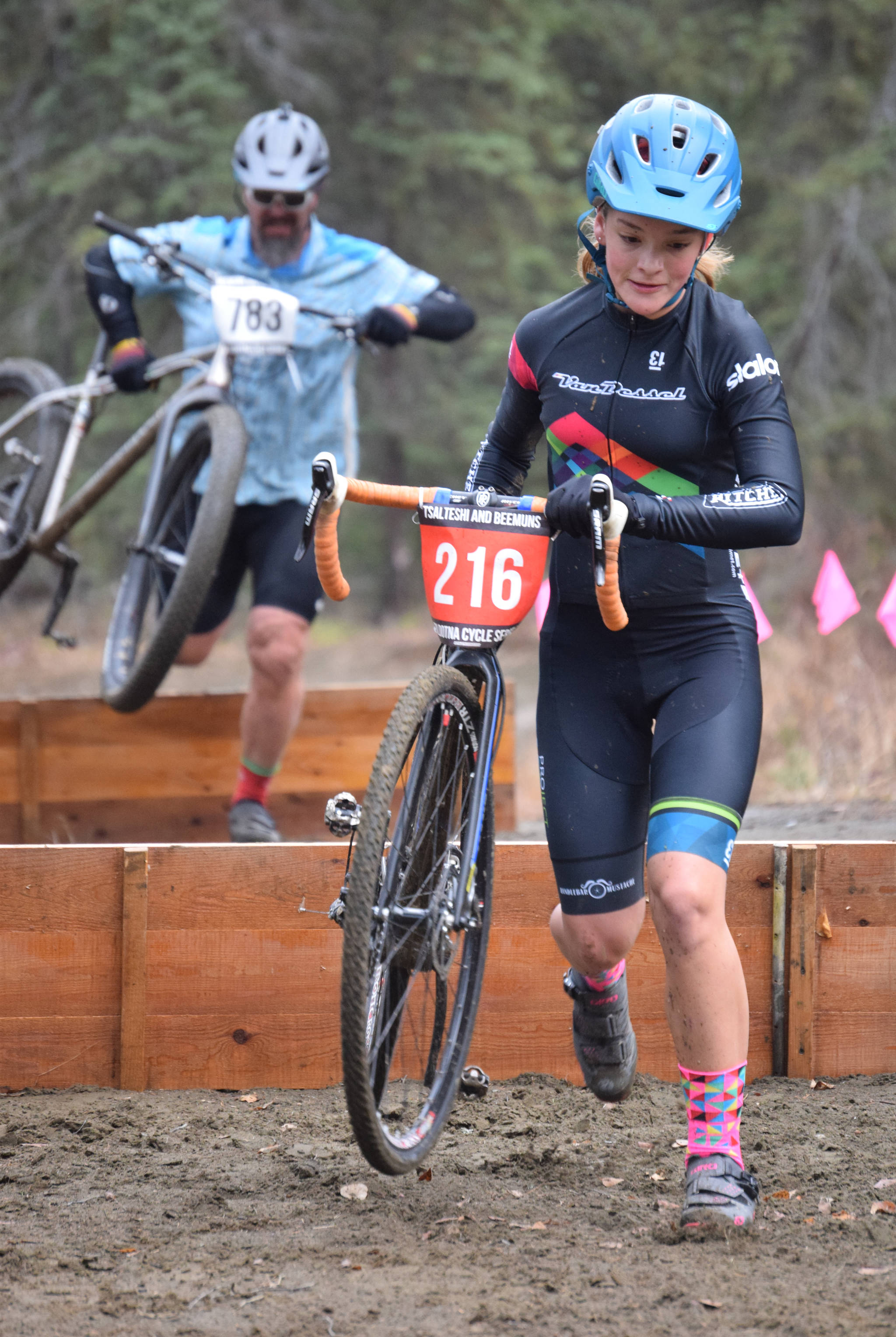 Kalima Glascott leads her father, Bob Glascott, over barriers at the Alaska Cyclocross State Championships on Saturday, Oct. 19, 2019, at Tsalteshi Trails near Soldotna, Alaska. The Glascotts are both from Anchorage. Kalima won the girls under-18 state title. (Photo by Jeff Helminiak/Peninsula Clarion)