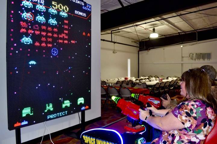 Patrons at the newly opened Kenai Extreme Fun Center play the “Space Invaders” game, in Kenai, Alaska, Wednesday, Oct. 23, 2019. (Photo by Victoria Petersen/Peninsula Clarion)
