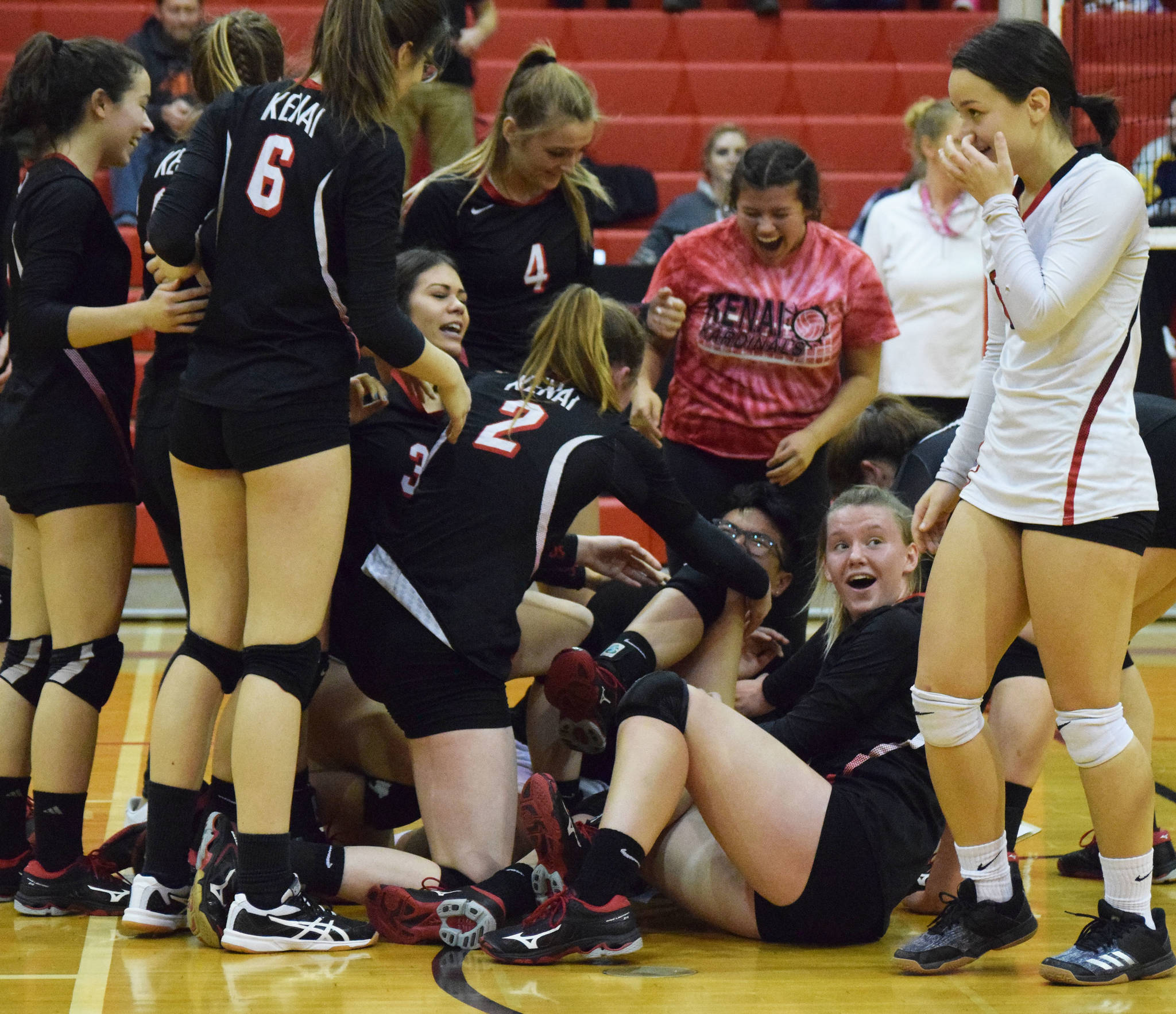 The Kenai Central volleyball team celebrates in a dogpile on the floor Thursday, Oct. 31, 2019, after defeating Soldotna at Kenai Central High School in Kenai, Alaska. (Photo by Joey Klecka/Peninsula Clarion)