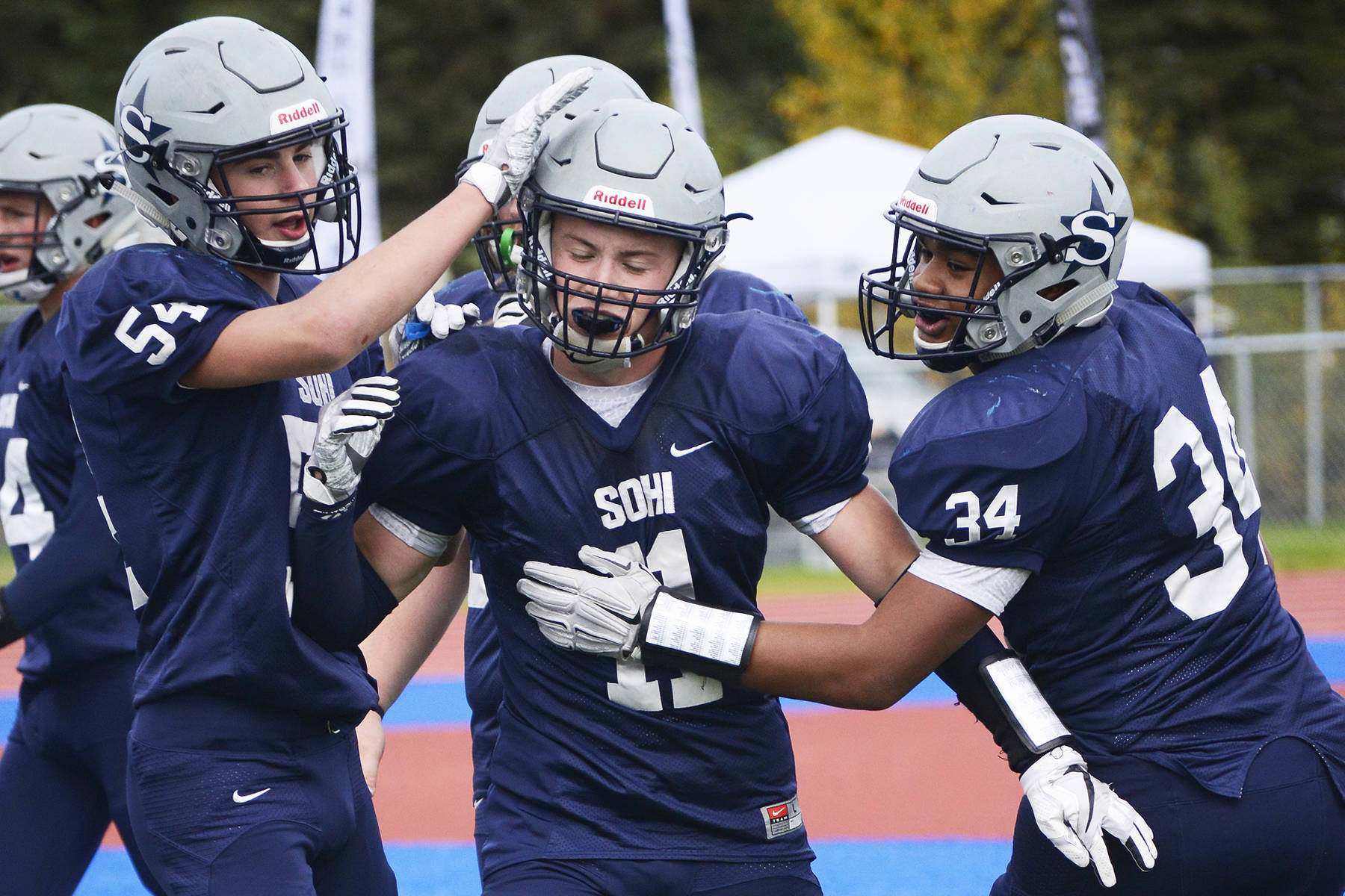 Soldotna running back Brenner Furlong (center) receives congratulations from teammates Zach Hanson (left) and Aaron Faletoi (right) after scoring a touchdown in Sept. 2017 at Justin Maile Field in Soldotna. (Photo by Joey Klecka/Peninsula Clarion)