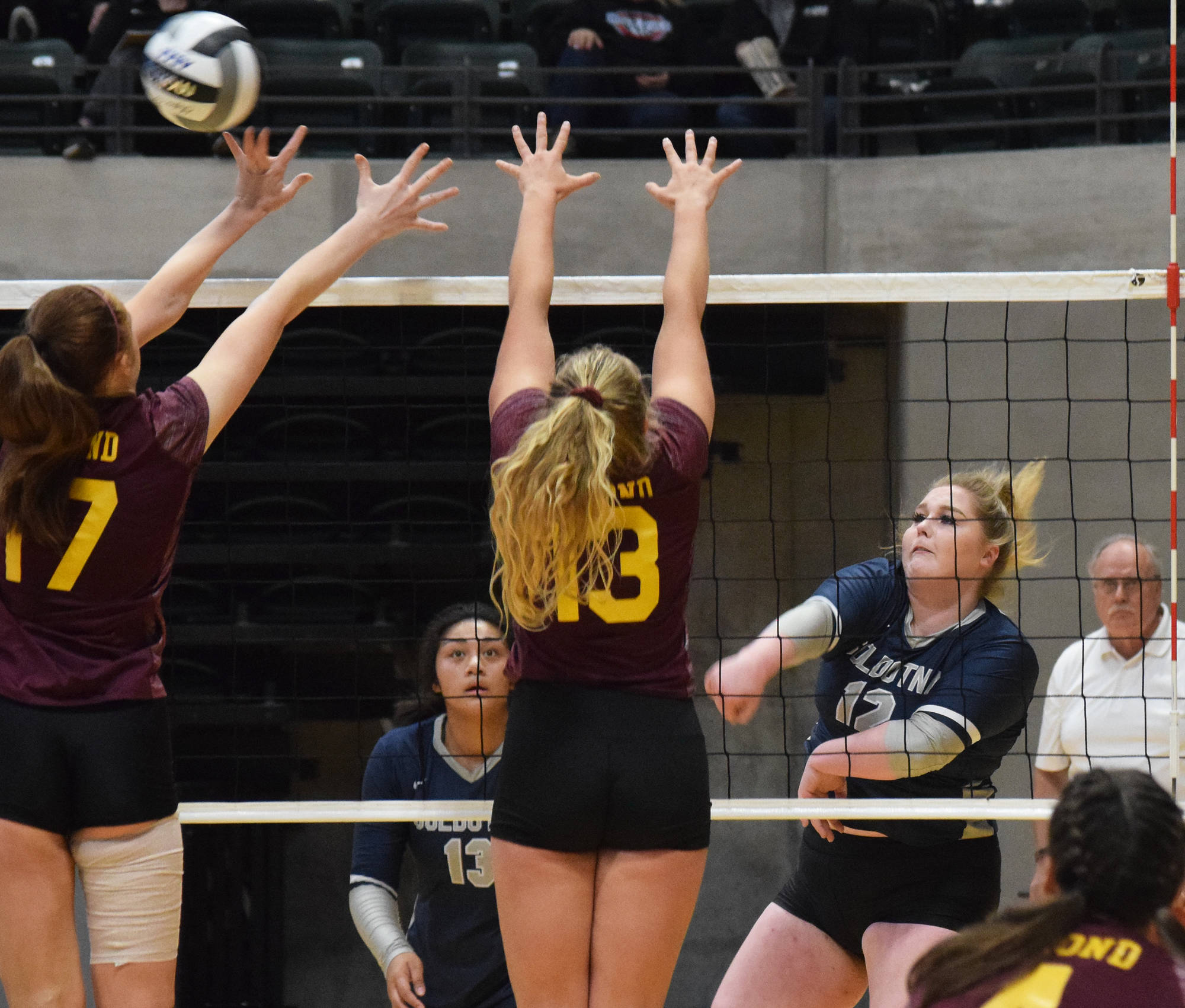Soldotna’s Bailey Armstrong sends a ball over Dimond’s Kimberly Roth (left) and Hahni Johnson, Thursday, Nov. 14, 2019, at the Class 4A state volleyball tournament at the Alaska Airlines Center in Anchorage, Alaska. (Photo by Joey Klecka/Peninsula Clarion)