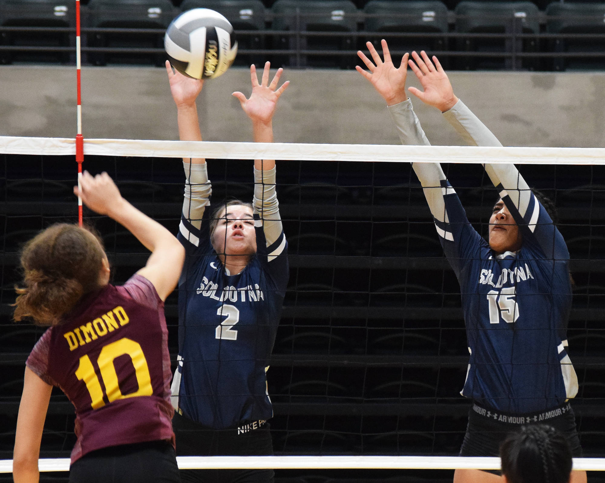 Soldotna’s Sierra Kuntz (2) and Serenia Foglia team up for a block on Dimond’s Taliyah Esters, Thursday, Nov. 14, 2019, at the Class 4A state volleyball tournament at the Alaska Airlines Center in Anchorage, Alaska. (Photo by Joey Klecka/Peninsula Clarion)